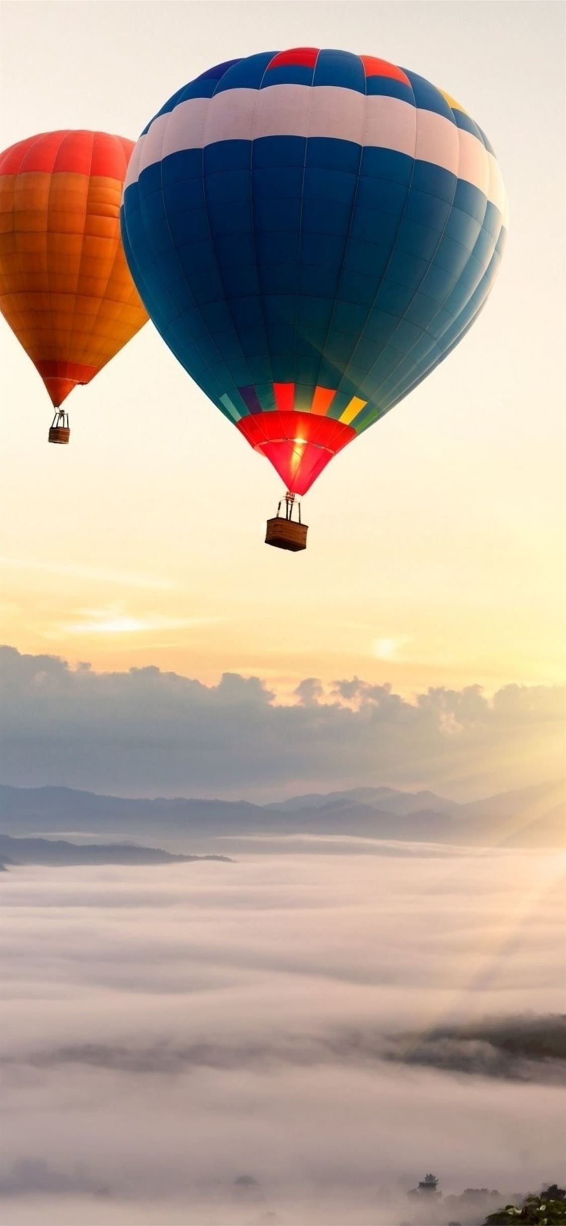 Air Sports: Mountain landscape, Two hot-air balloons floating over the fog in sunlight. 1130x2440 HD Background.