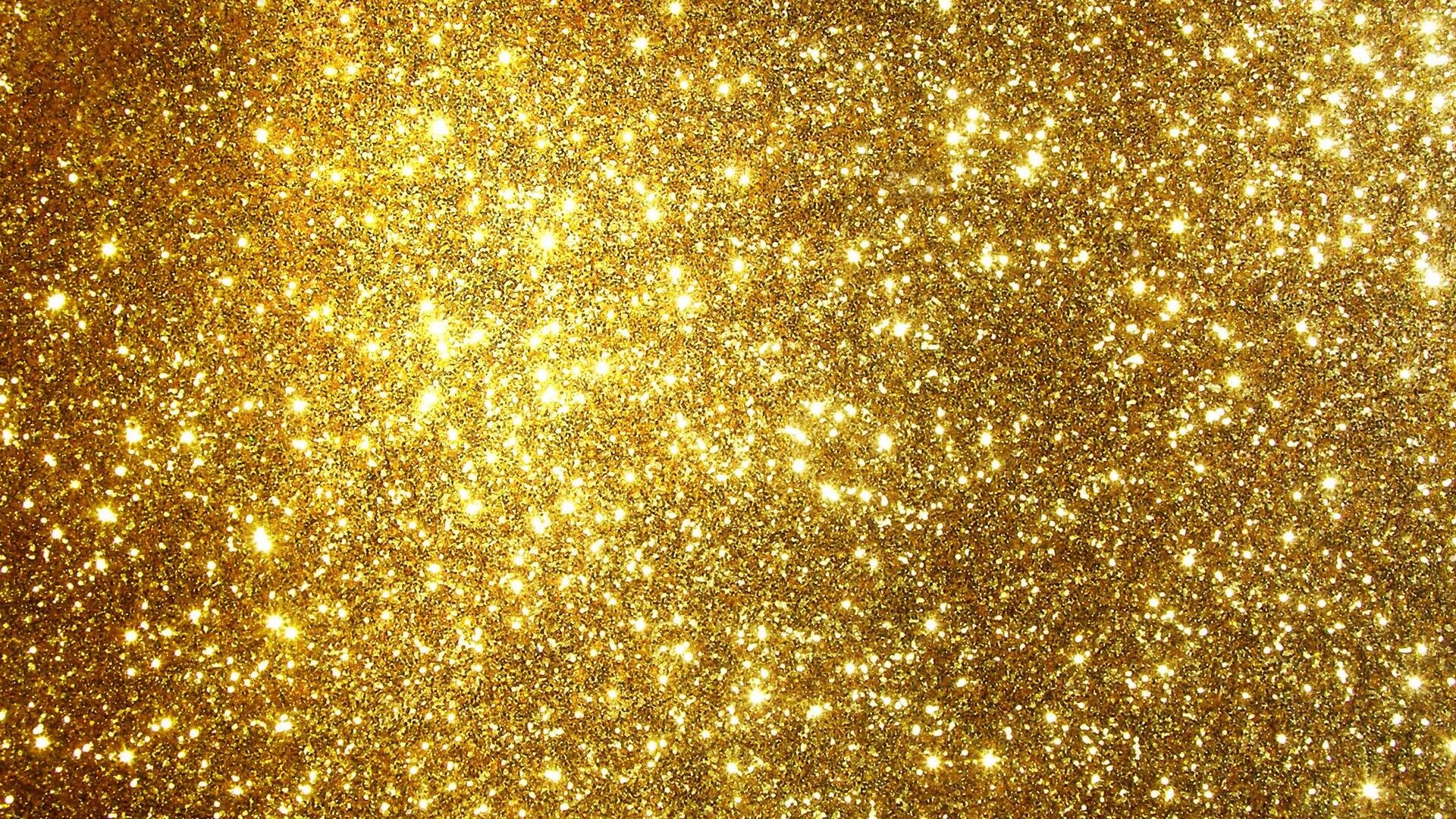 Gold Glitter: The solid surface decorated with shiny golden particles. 1920x1080 Full HD Background.