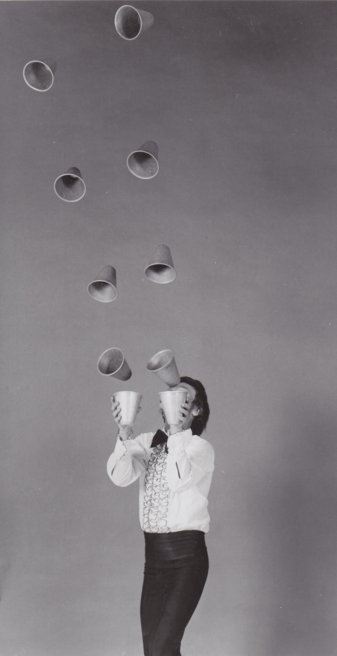 Juggling: Monochrome juggler uses paper cups as his props to show various artistic tricks. 1300x2520 HD Background.