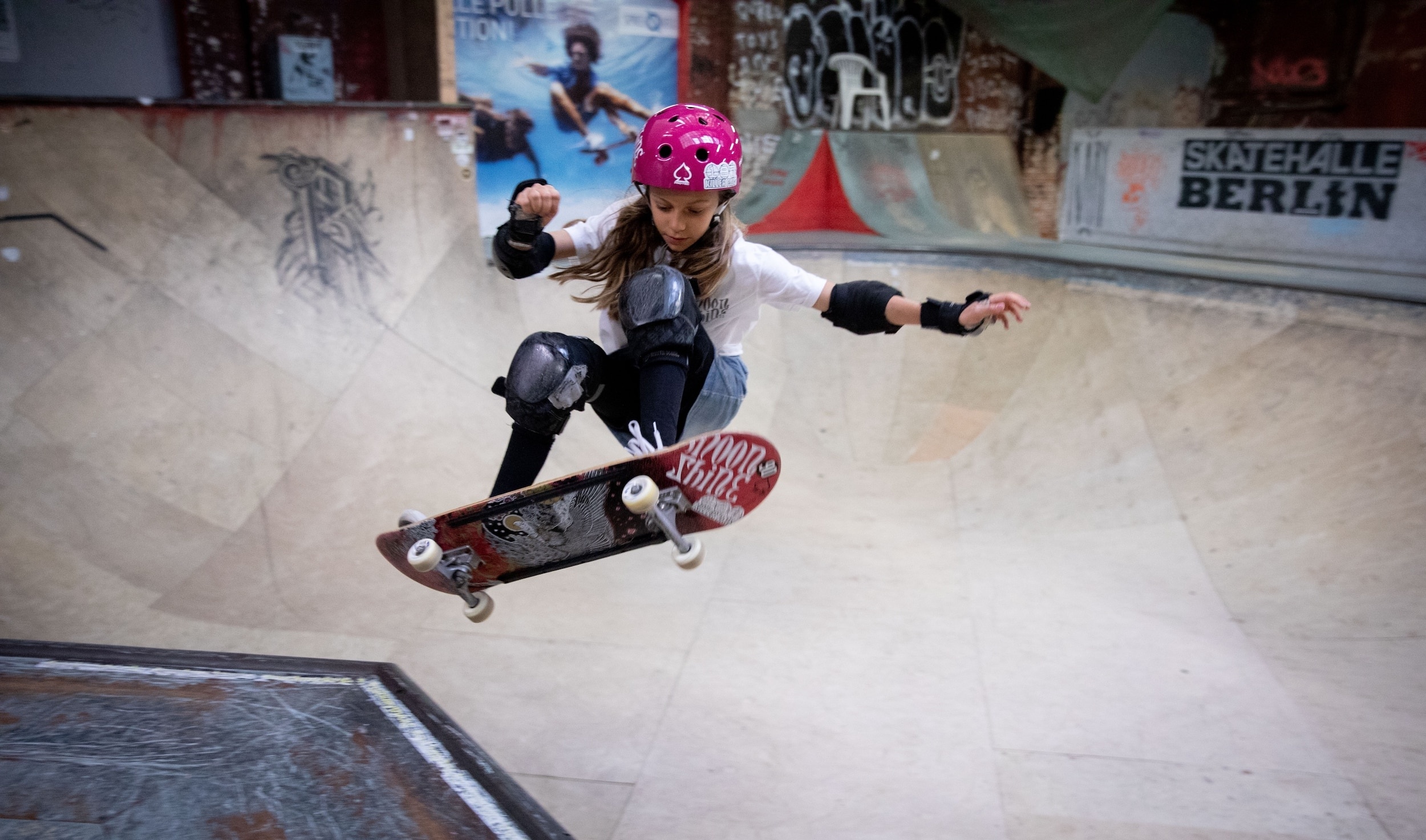 Skateboarding: Young skater is training to perform freestyle tricks on a skateboard, City Skatepark Arena. 2500x1480 HD Background.