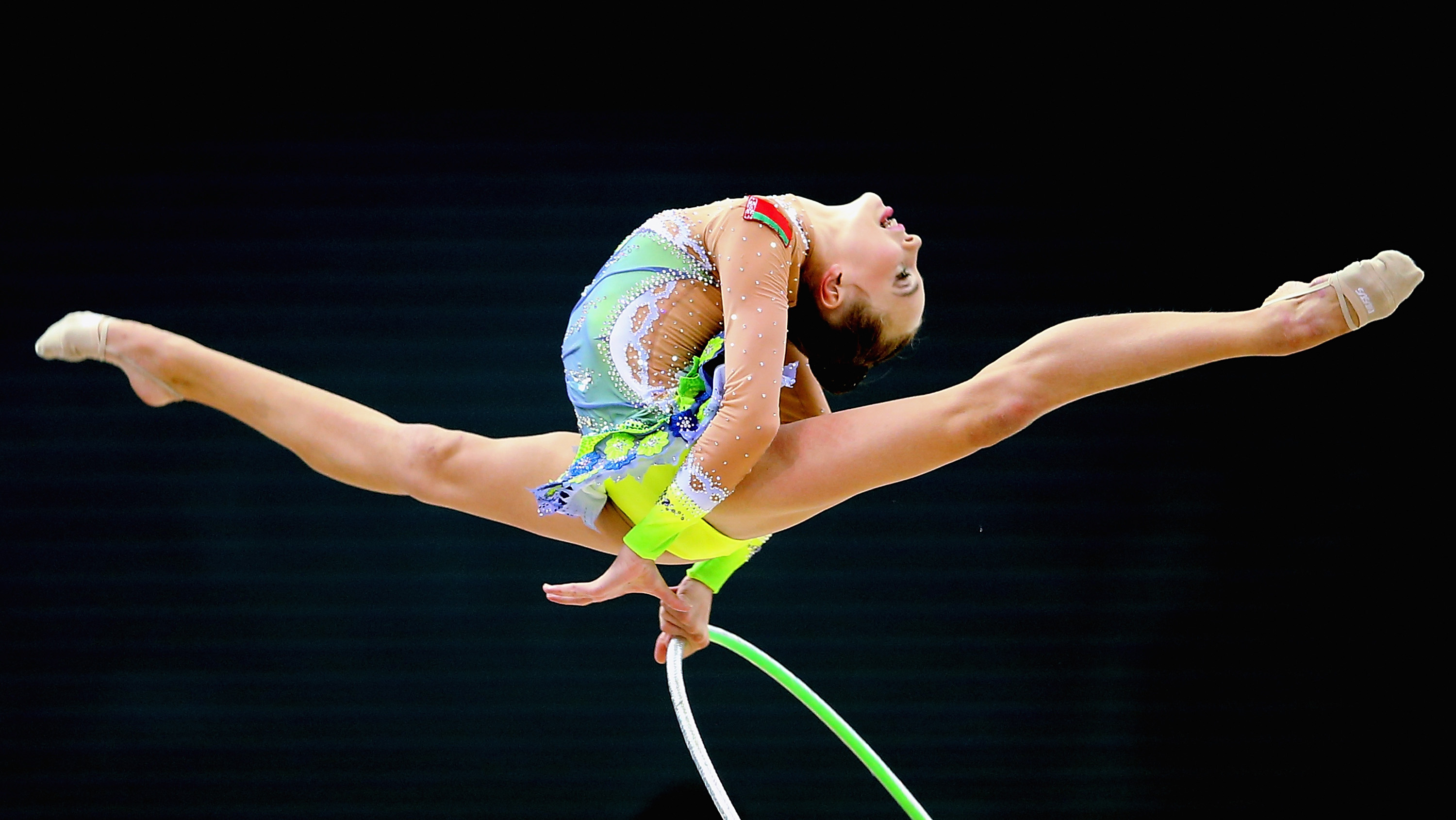 Rhythmic Gymnastics: A young Belarusian individual gymnast performs with a hoop, Competitive event. 3000x1690 HD Background.