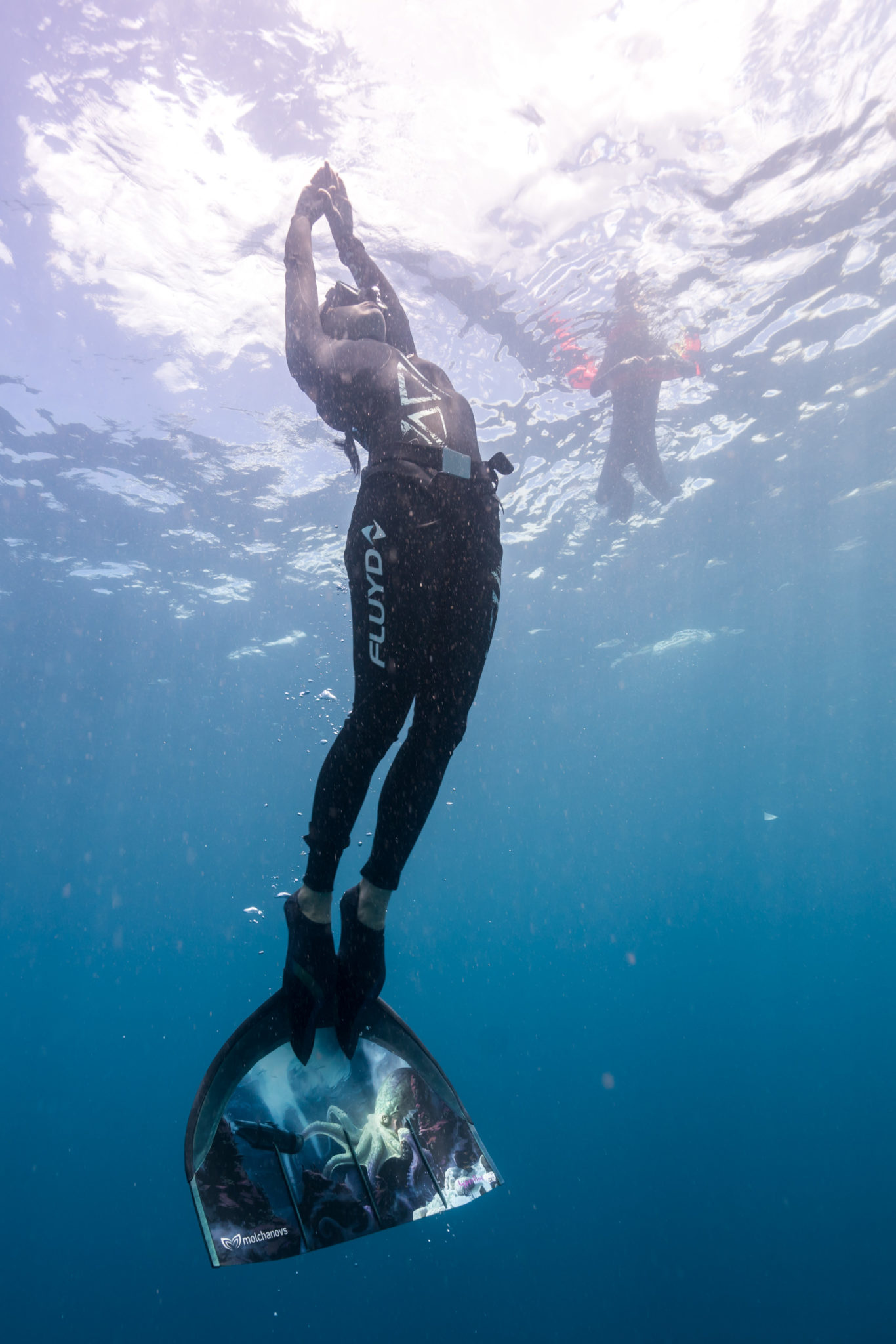 Freediving: Ascending with a monofin - a type of swimfin that emulates a fluke. 1370x2050 HD Wallpaper.