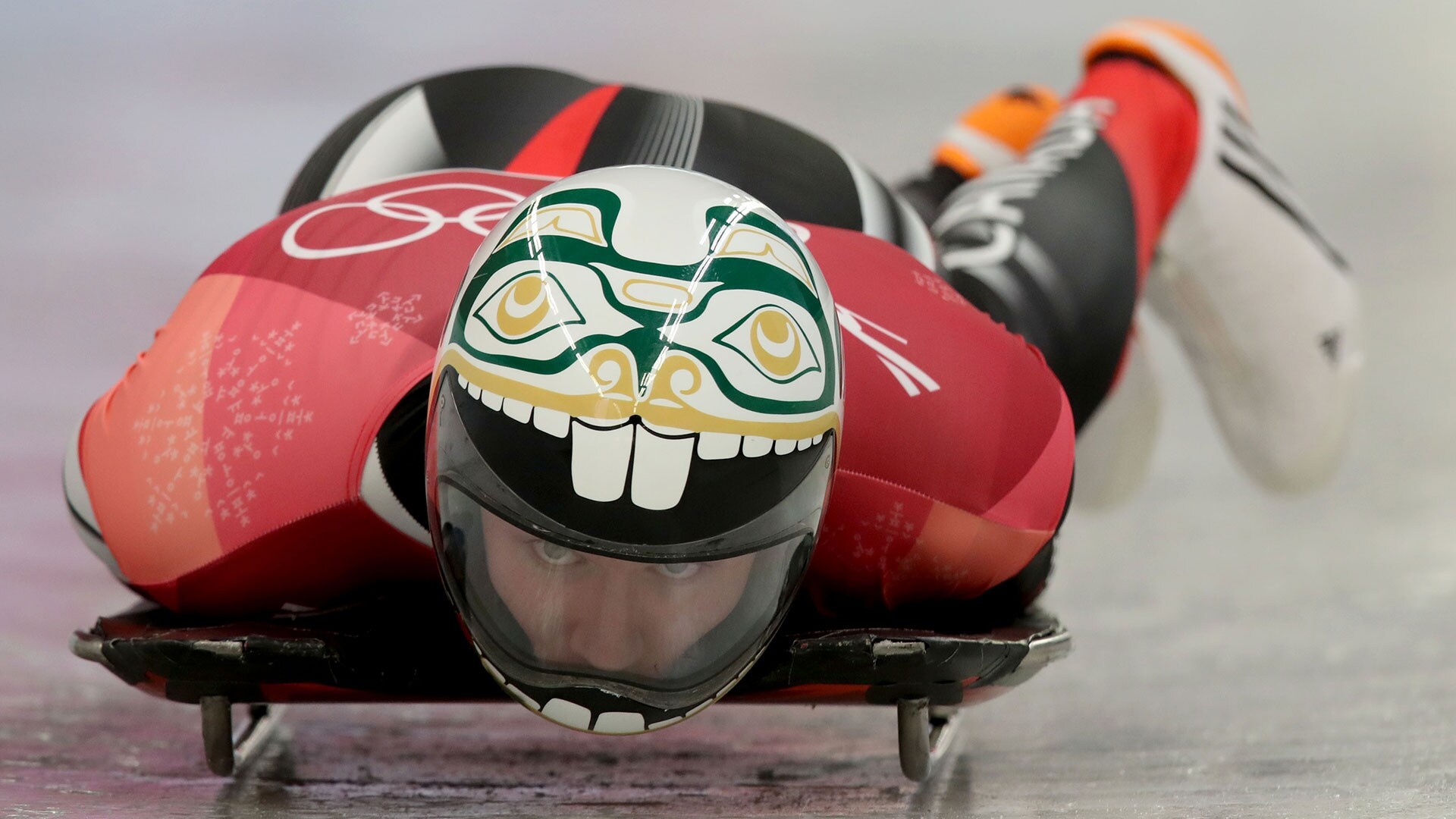 Skeleton (Sport): An athlete competes at the 2018 Winter Olympics wearing a custom helmet. 1920x1080 Full HD Background.