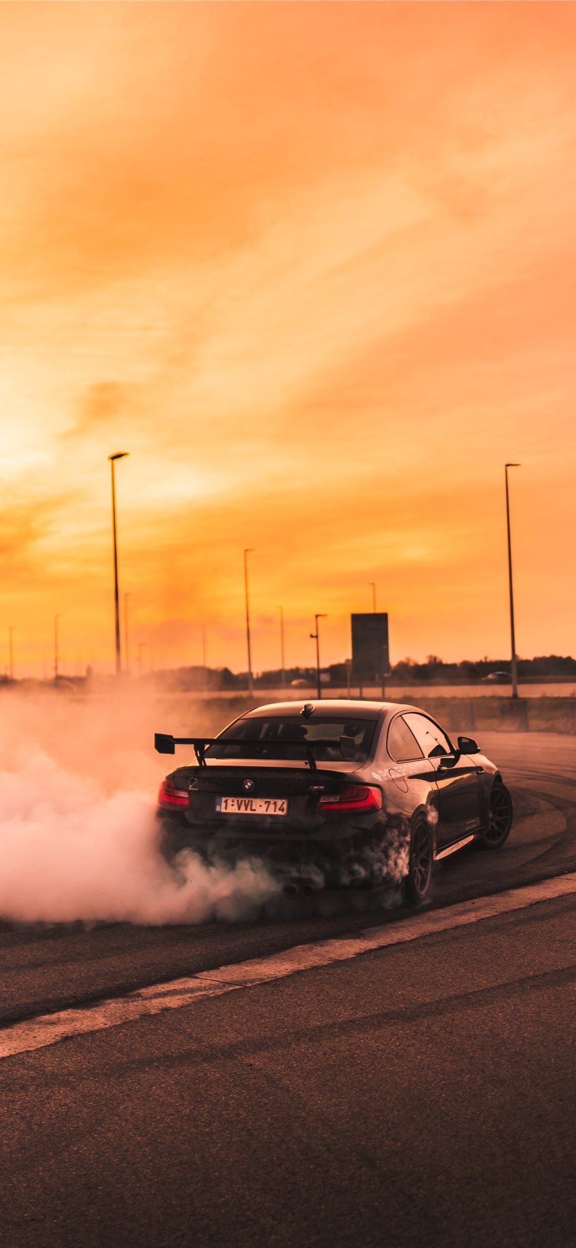Drifting: Black BMW M2, A high-performance sports car, Smoking tires. 1130x2440 HD Wallpaper.
