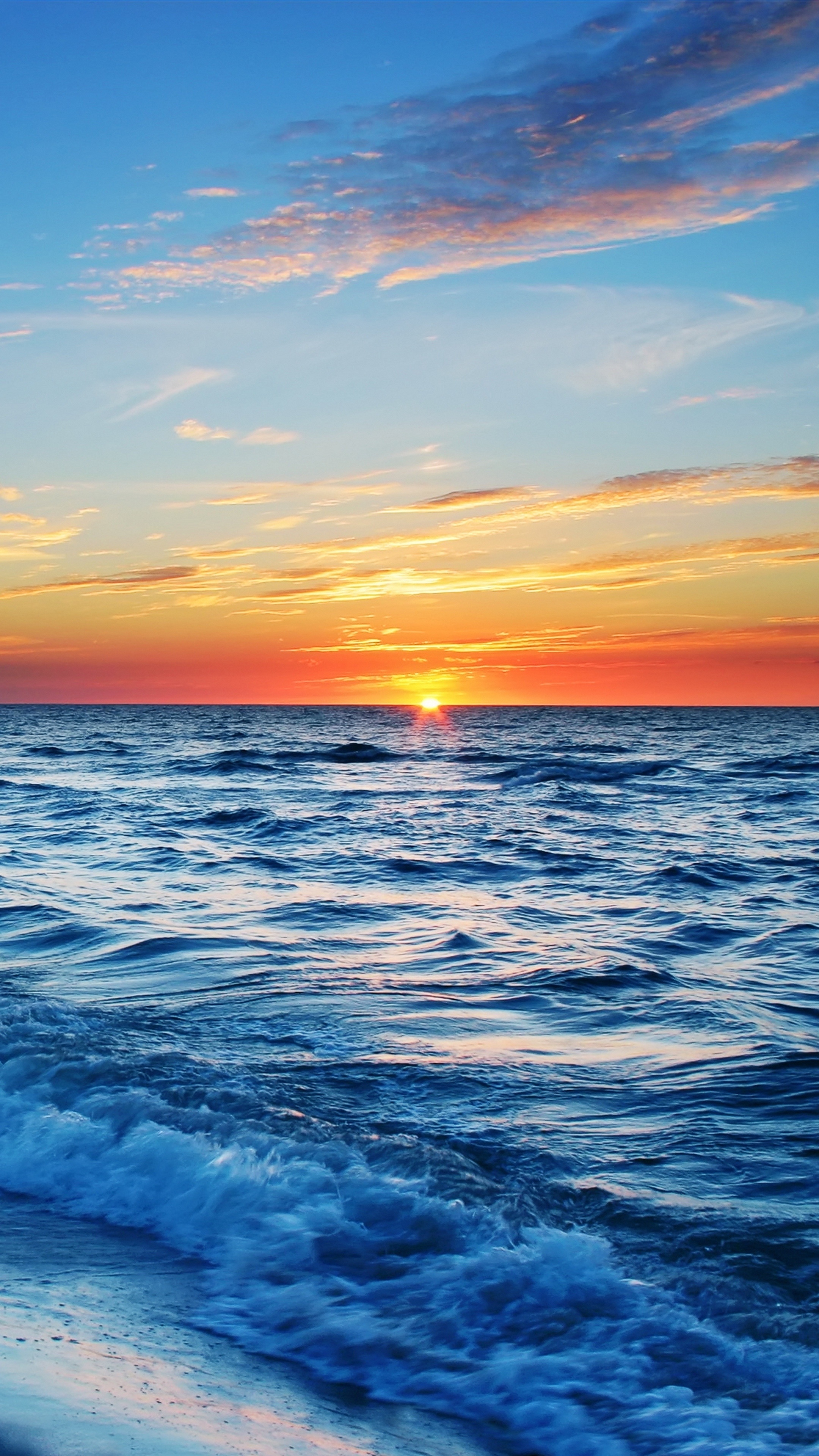 Seascape: The marvelous sunset view from the sea beach, attacked by small waves. 2160x3840 4K Background.