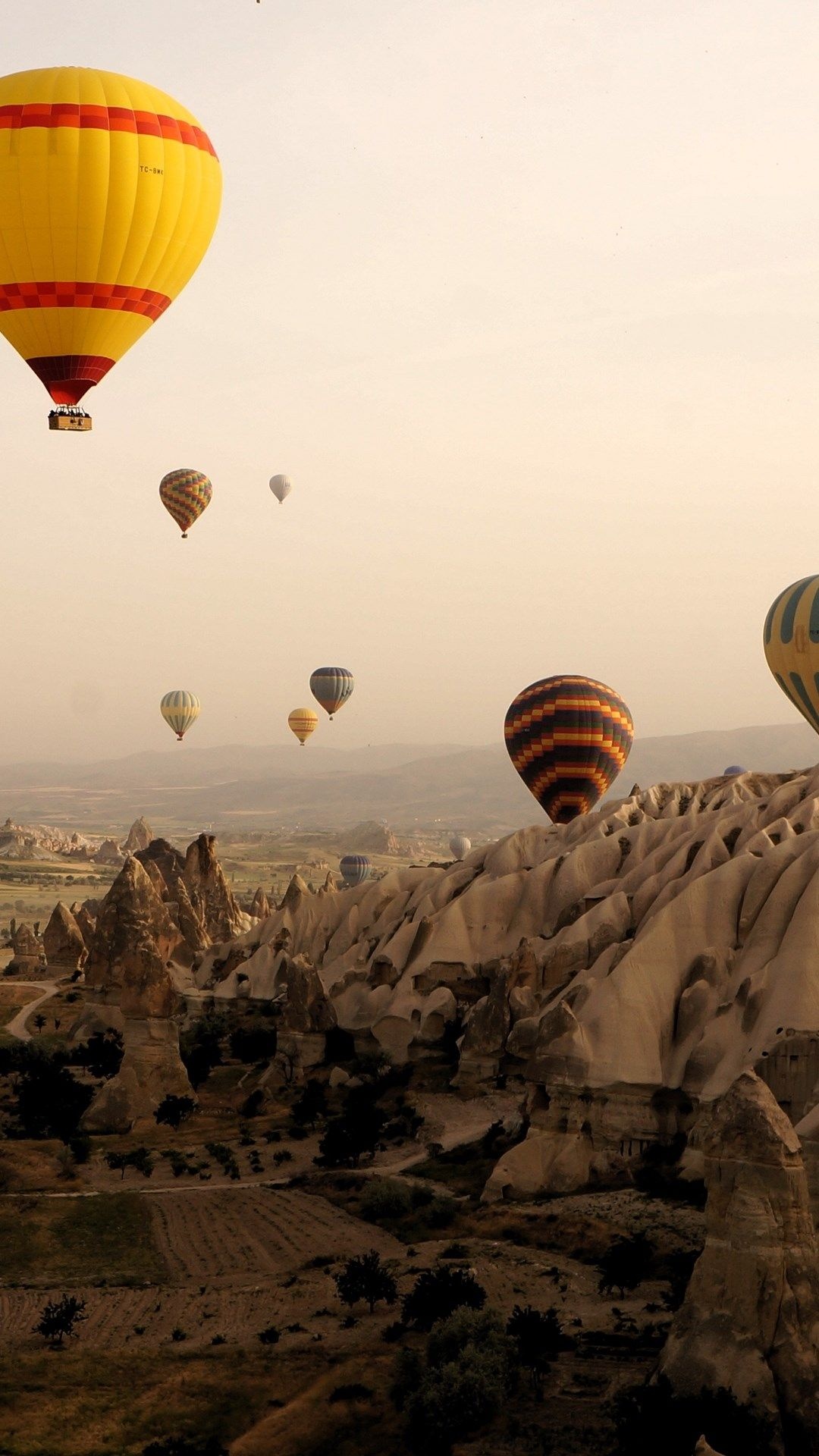 Air Sports: Lighter-than-air aircraft floating in a rock valley, Cappadocia, Hot air ballooning. 1080x1920 Full HD Wallpaper.