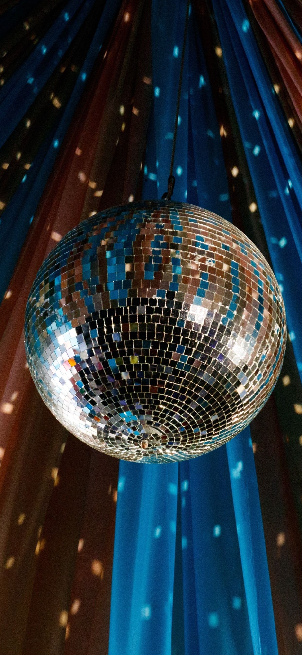 Disco: The best party atmosphere, A distinctive vibe, A suspended rotating mirrored sphere. 1250x2690 HD Background.