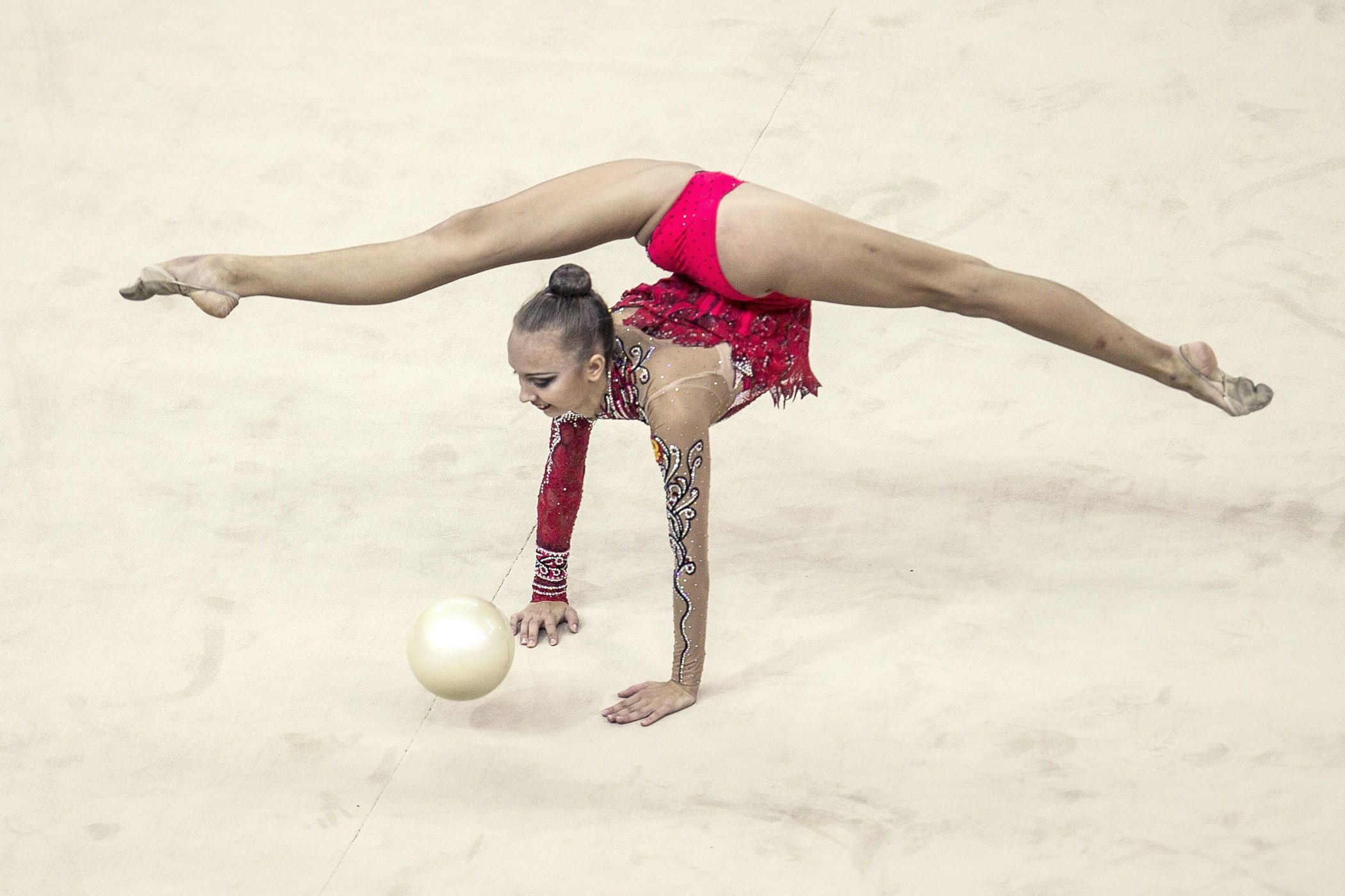 Floor (Gymnastics): An artistic exercise with a special ball, Sports choreography performed by a female gymnast. 2100x1400 HD Background.