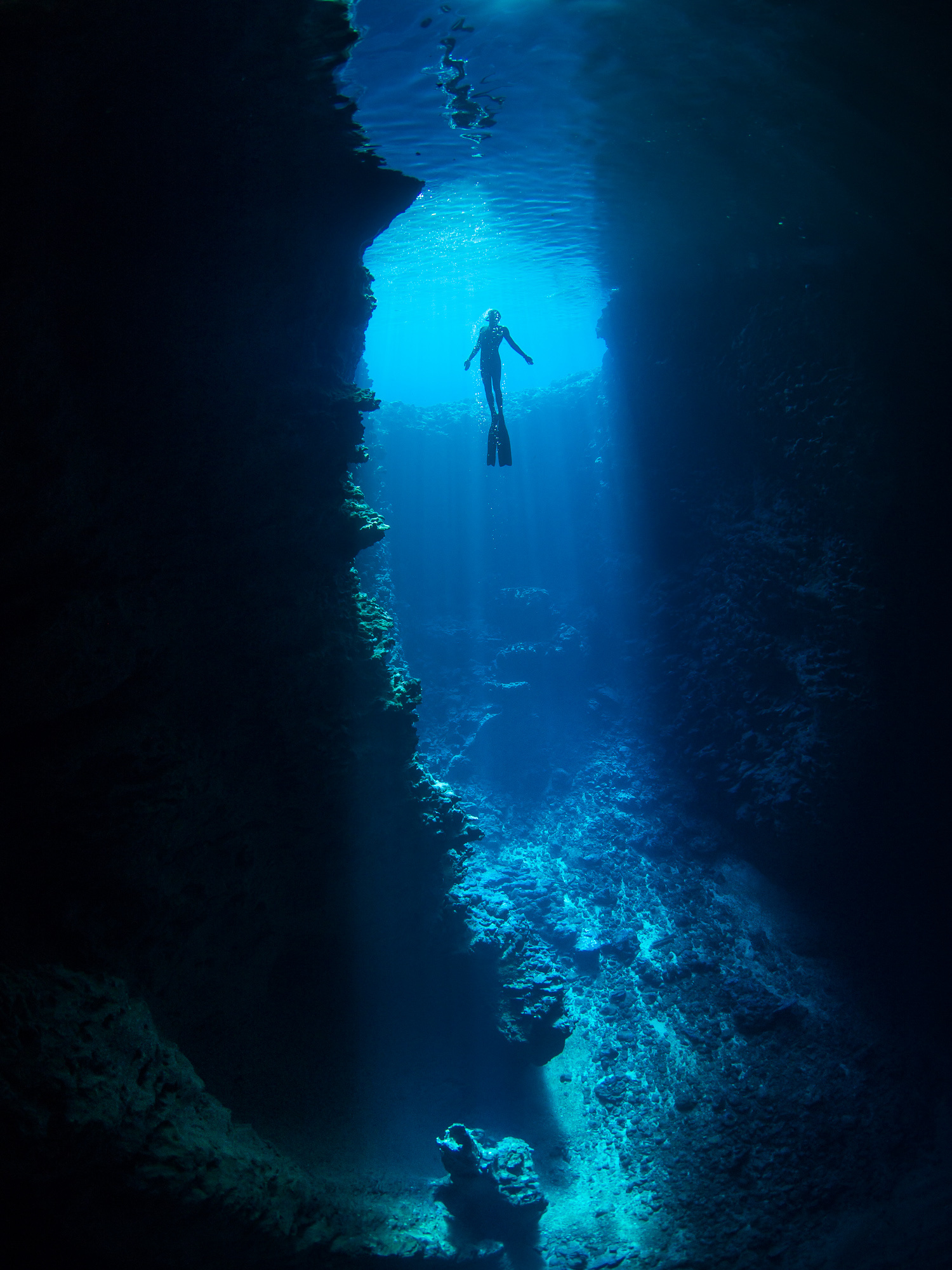 Freediving: A couple explores the flooded cave without special equipment. 1500x2000 HD Background.