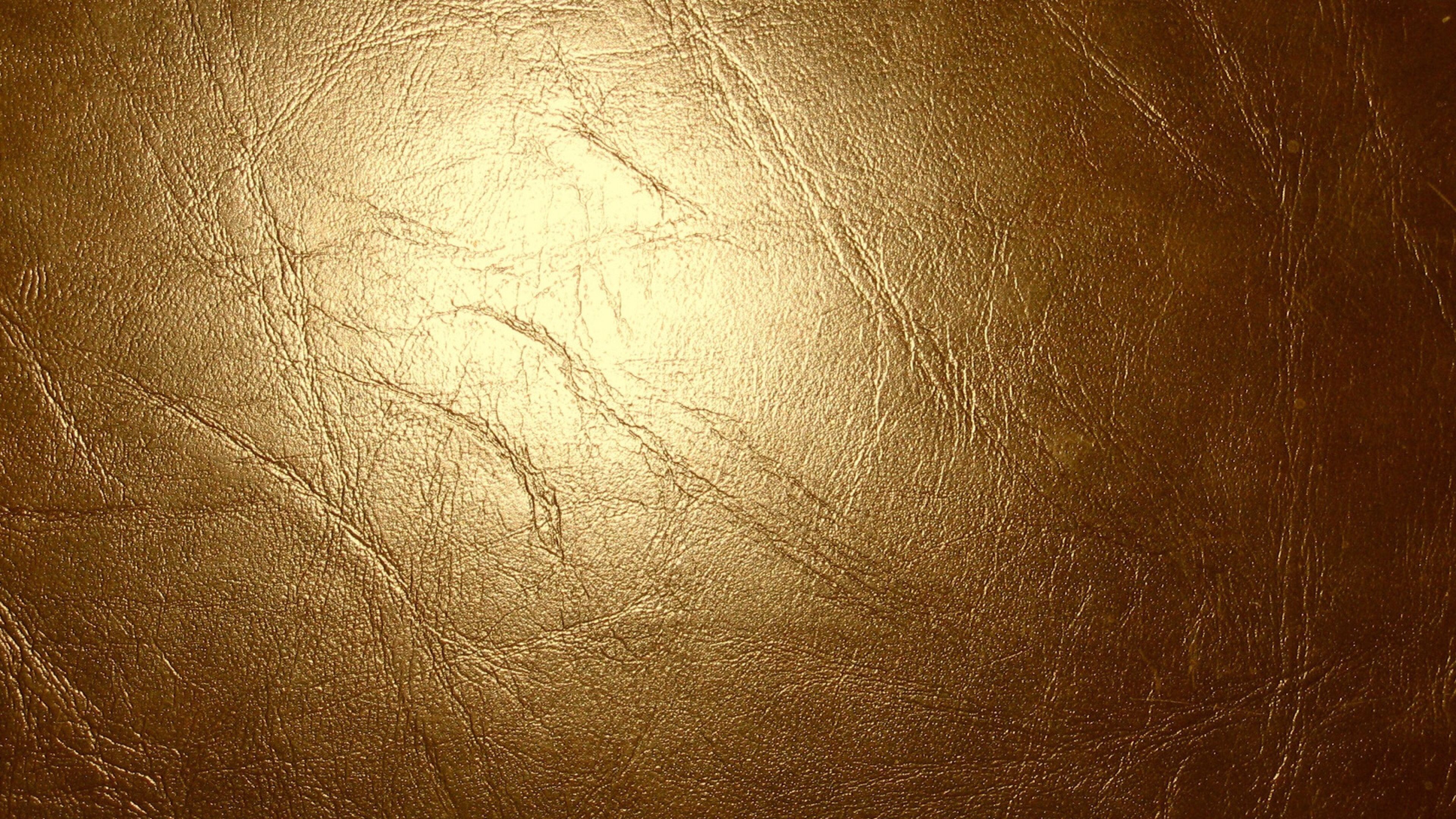 Gold Glitter: The leather texture slightly covered with thin sheets made of precious metal. 3840x2160 4K Background.