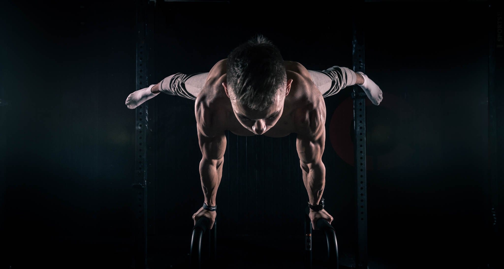 Calisthenics: An advanced strength exercise, A combo planche-push-up exercise performed by a professional gymnast. 2050x1100 HD Background.