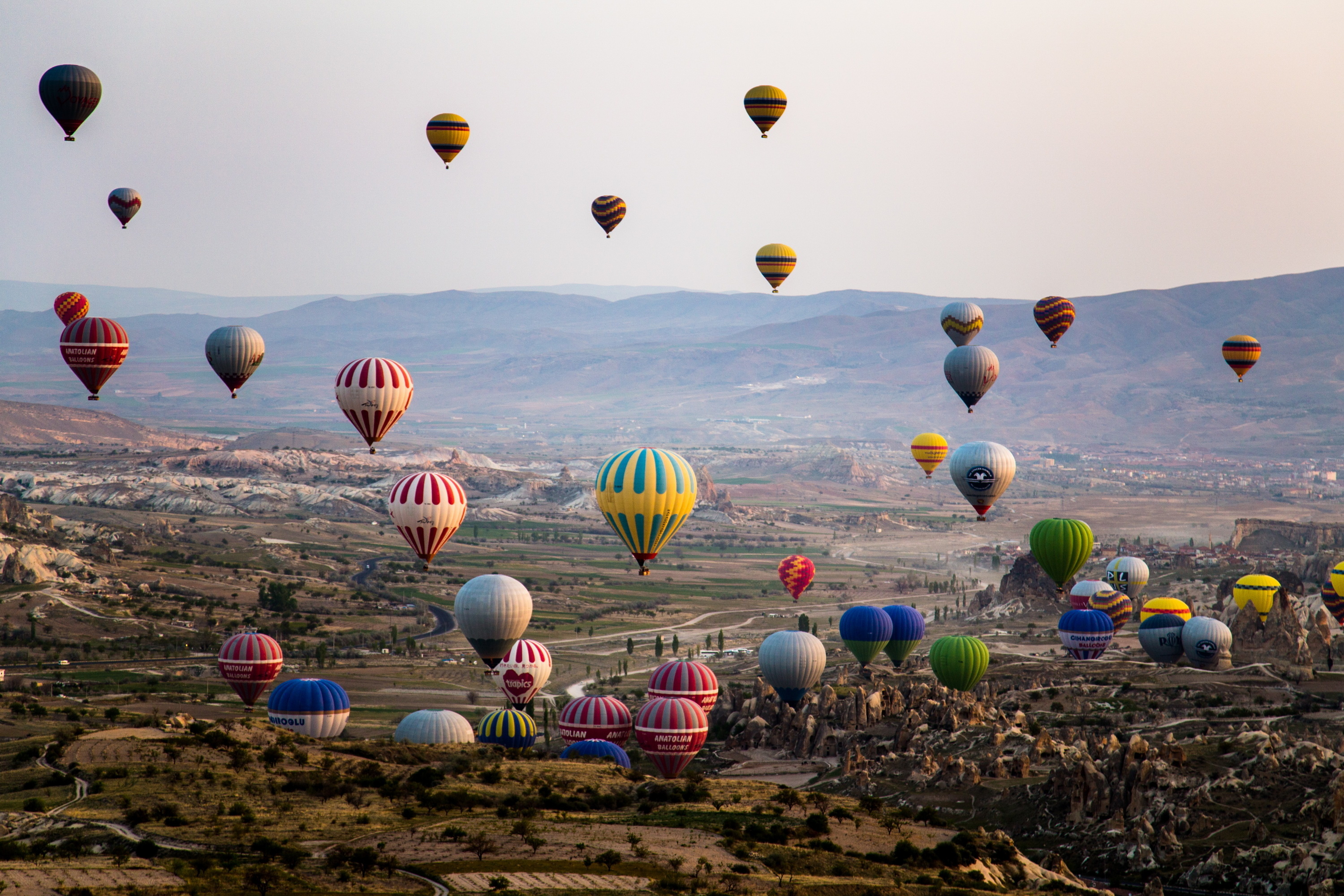 Air Sports: Hot-air balloons fill up a valley, Flying festival in Turkey, Cappadocia. 3000x2000 HD Background.