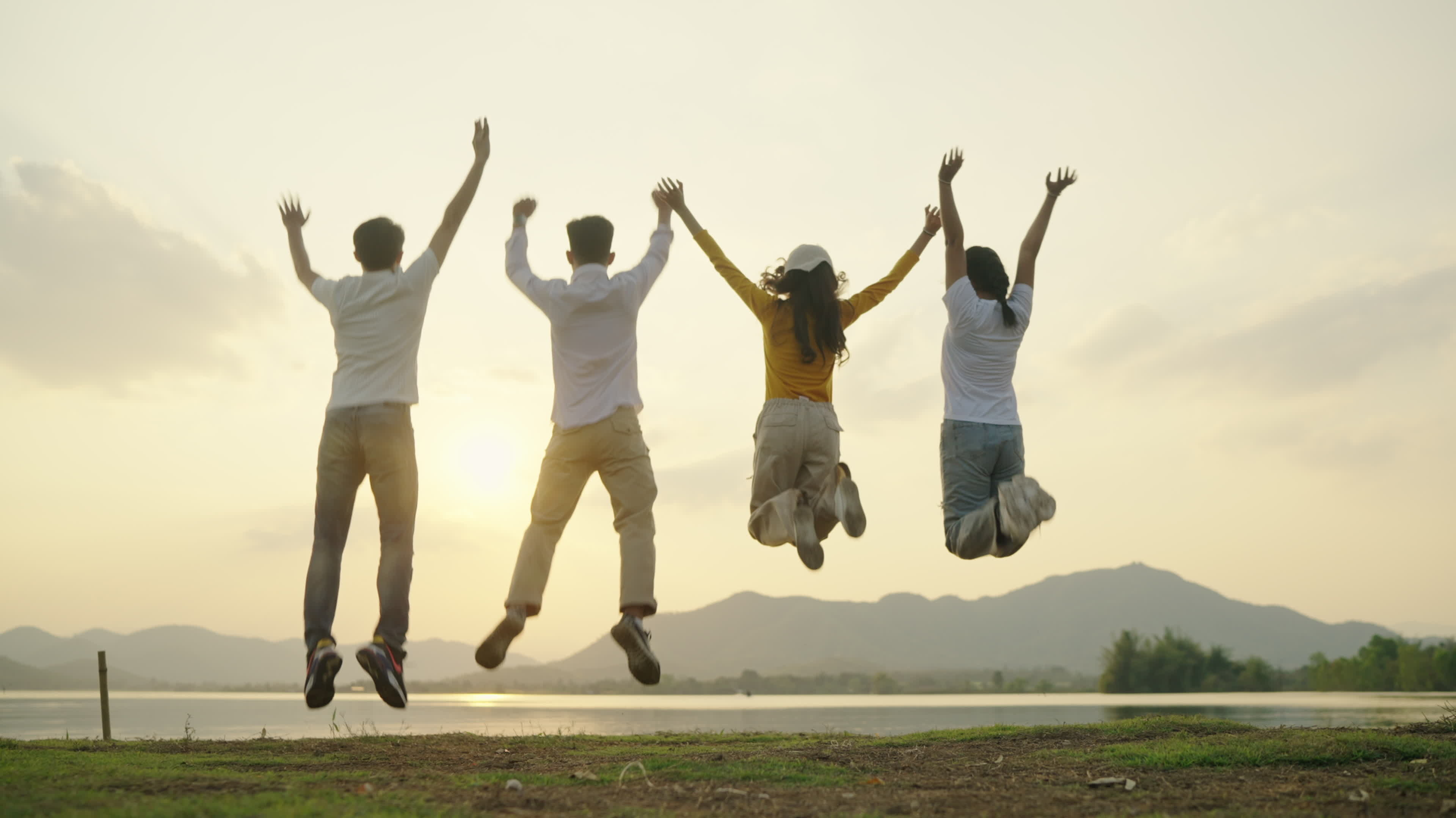 Jumping: Four people, Group of happy teenagers, Raising hands, Sunset, Mountain and river. 3840x2160 4K Wallpaper.