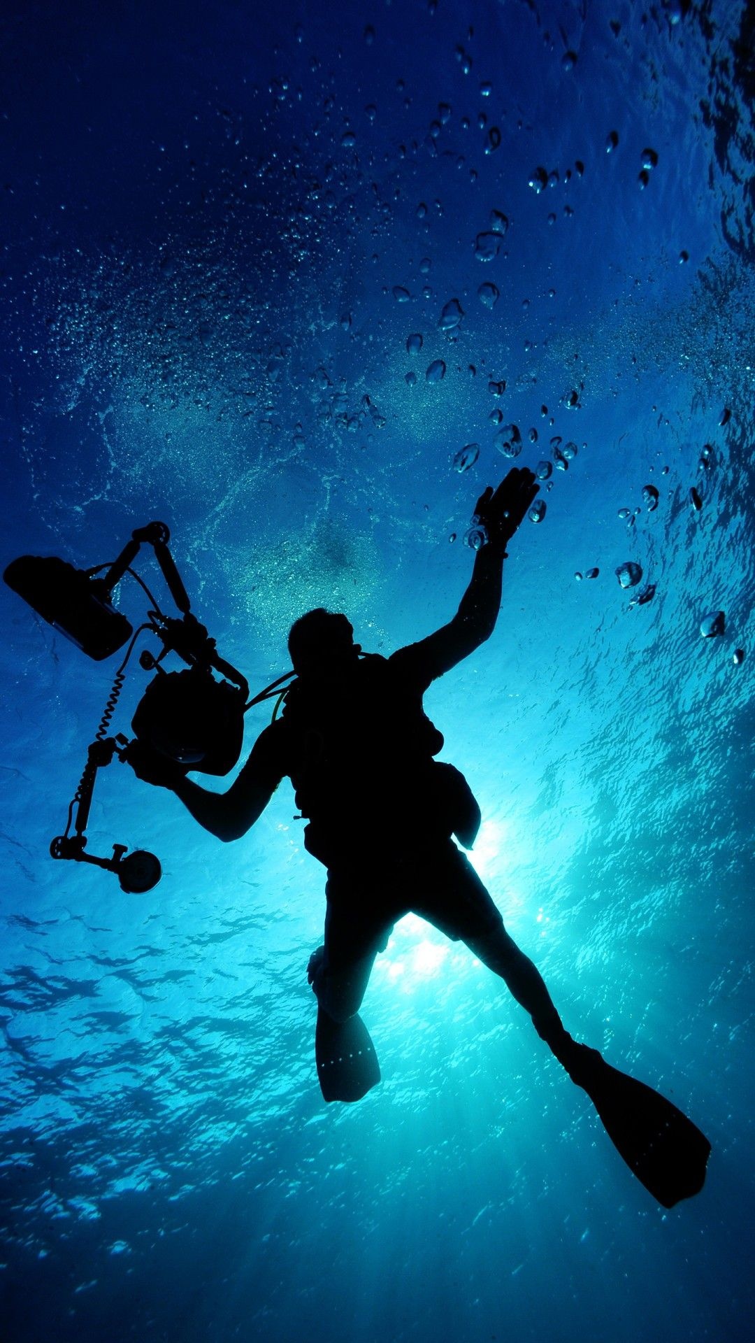 Diving: A professional scuba diver equipped with an underwater camera. 1080x1920 Full HD Background.