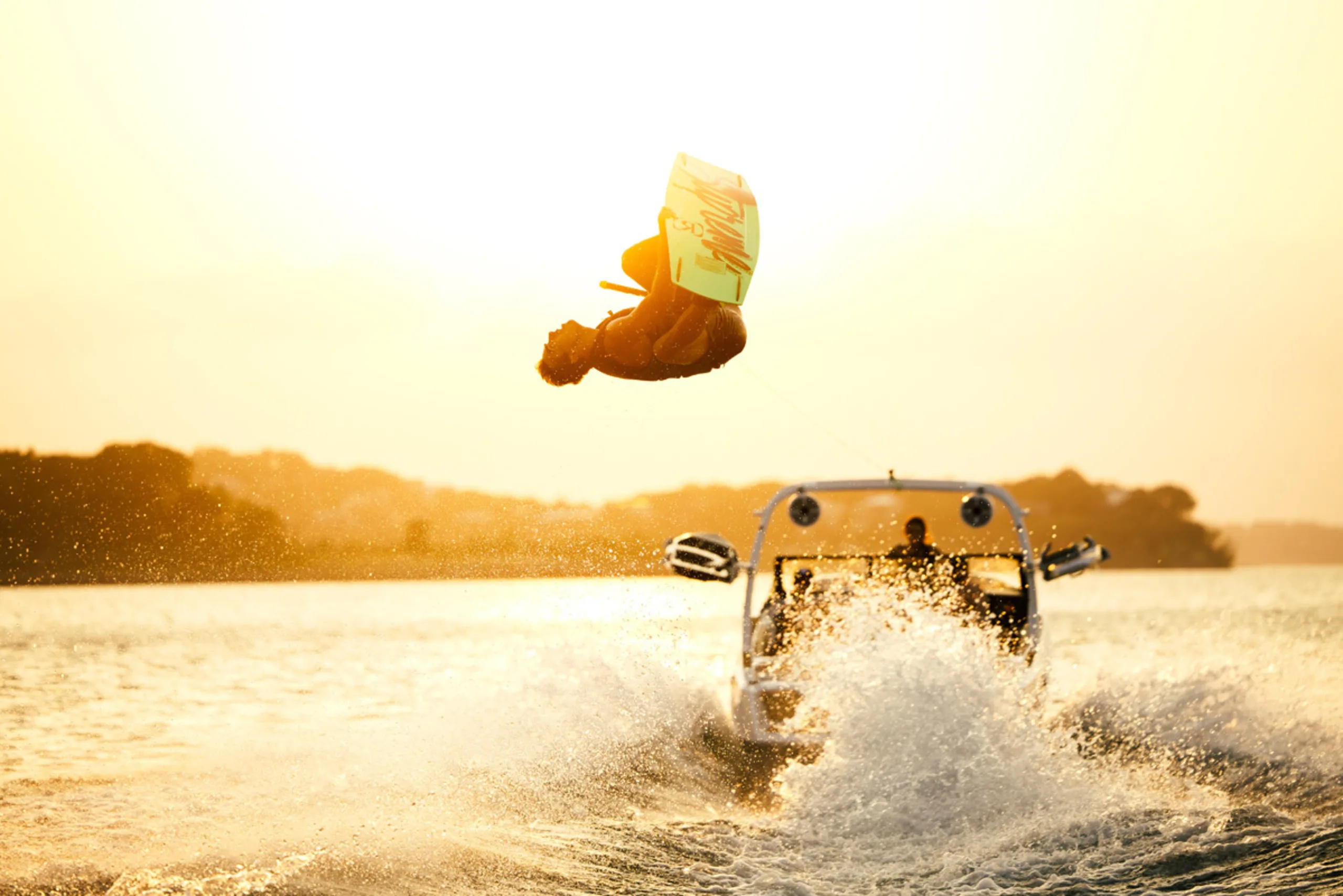 Wakeboarding: A wakeboard (a short board with foot bindings) is towed behind ATX Surf Boat. 2560x1710 HD Background.