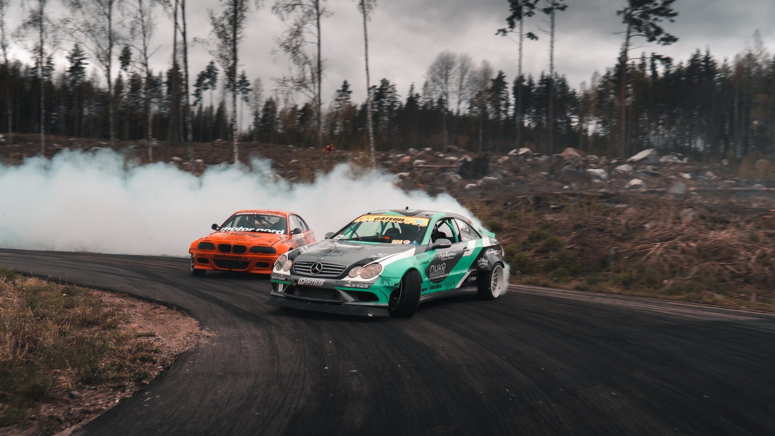 Drifting: Mercedes C-Class Coupe vs. BMW, Extreme turning during the race, Smoking tires. 2500x1410 HD Background.