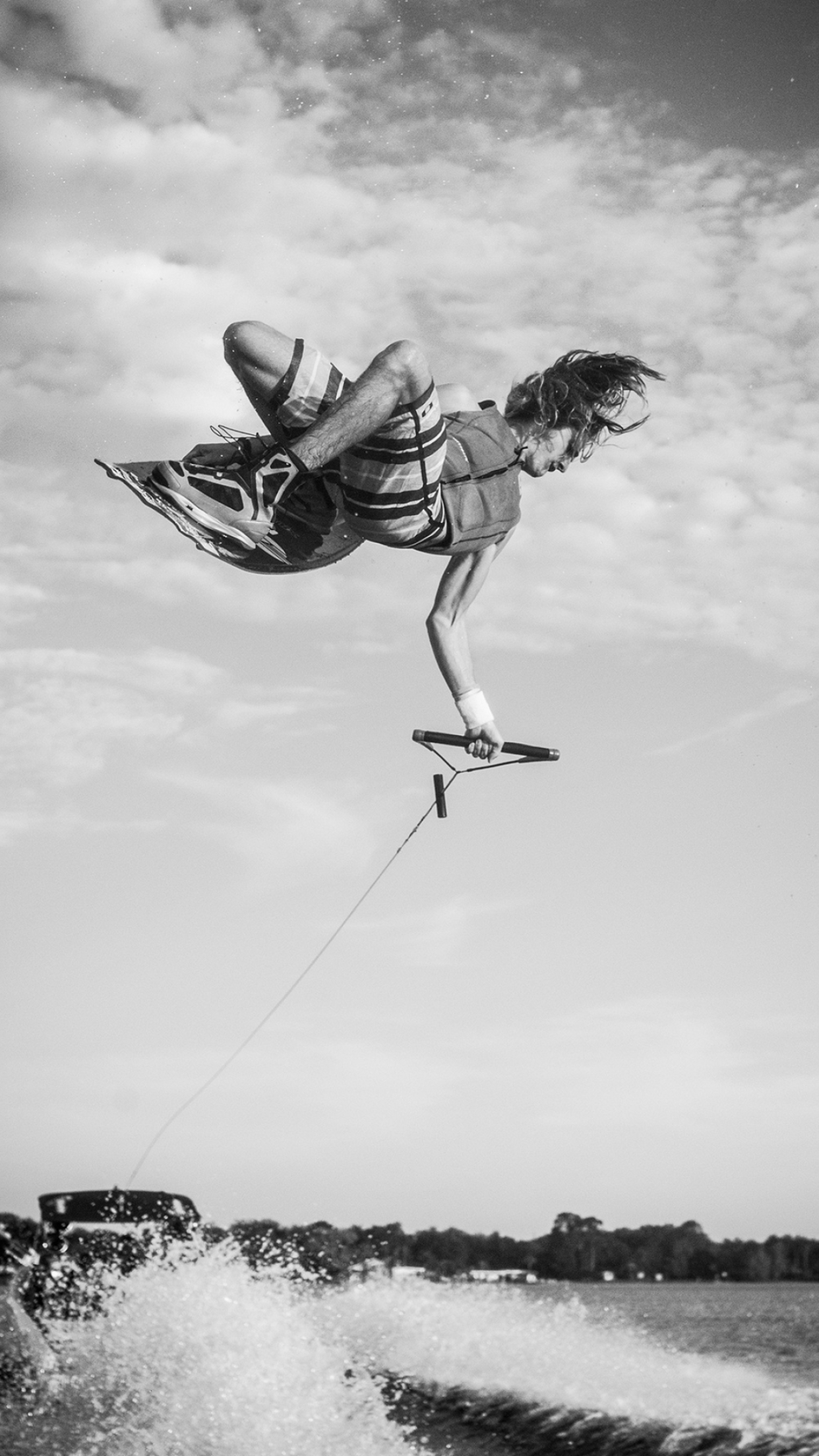 Wakeboarding: Monochrome water athlete performing a high-risk aerial trick, Riding a wakeboard, Extreme sport. 1250x2210 HD Background.