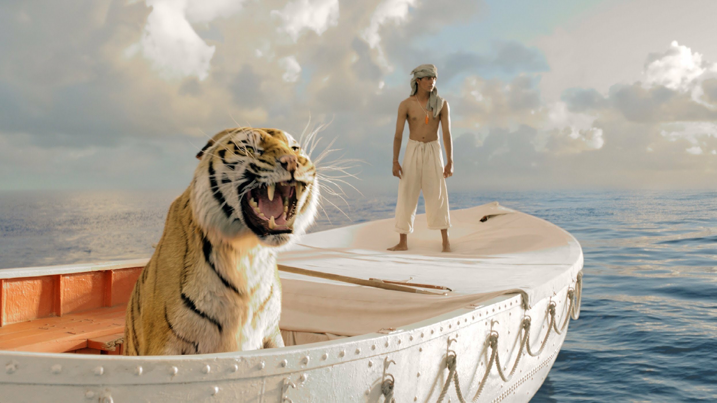 Life of Pi: The heart of the film focuses on the sea journey, during which the human demonstrates that he can think with great ingenuity and the tiger shows that it can learn. 2490x1410 HD Background.