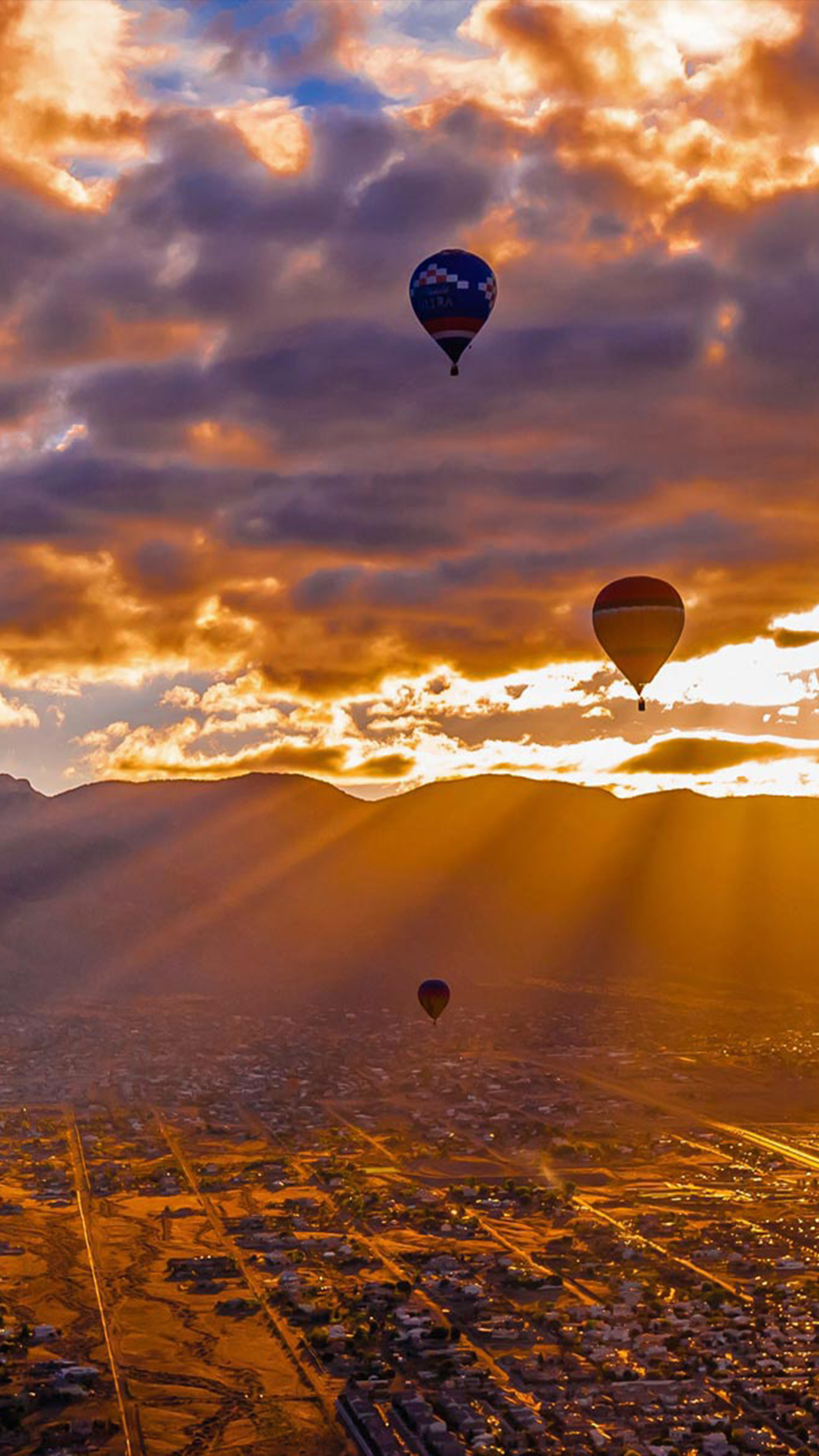 Air Sports: Balloons Festival, Floating vehicles up to the sky around the city surrounded by mountains in the sunset. 2160x3840 4K Wallpaper.