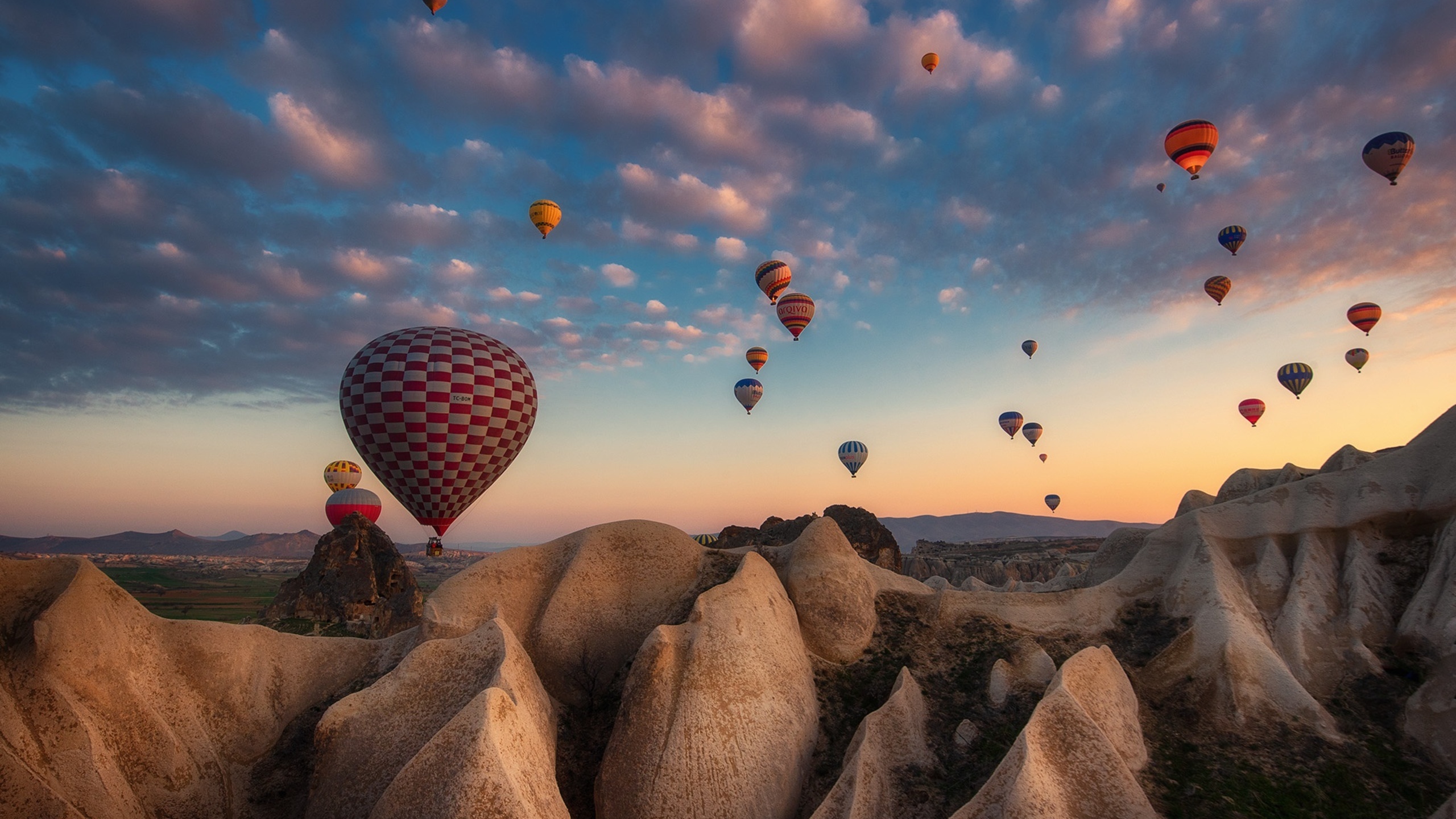 Air Sports: Lighter-than-air crafts gently ebbing and flowing in Cappadocia in Central Turkey, The panoramic view of hundreds of hot-air balloons. 2560x1440 HD Background.
