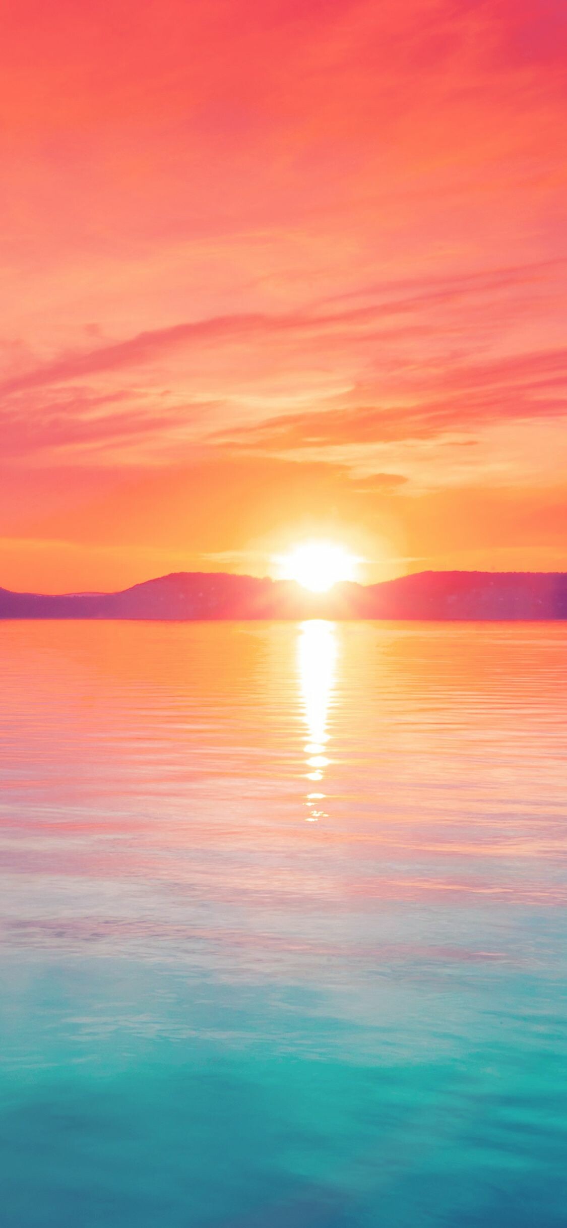 Sunset: The broad expanse of water reflecting the setting sun. 1130x2440 HD Background.
