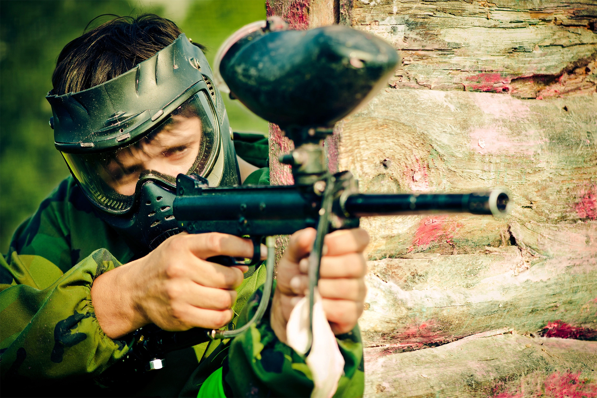 Paintball: A gun sports player aims with a marker, Outdoor recreational activity. 2000x1340 HD Background.