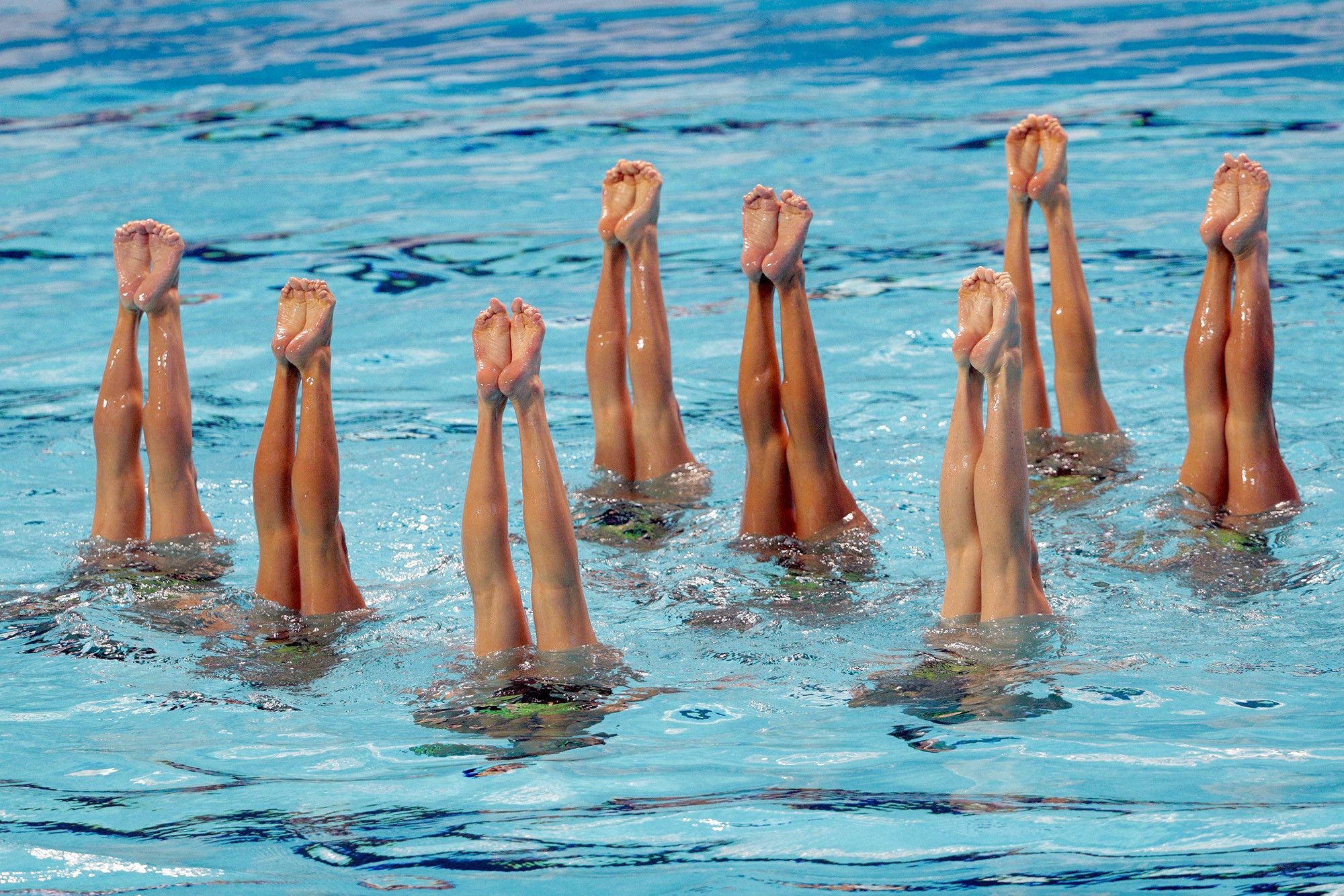 Synchronized Swimming: A competitive water sport where swimmers perform a synchronized choreographed routine, accompanied by music. 2000x1340 HD Background.