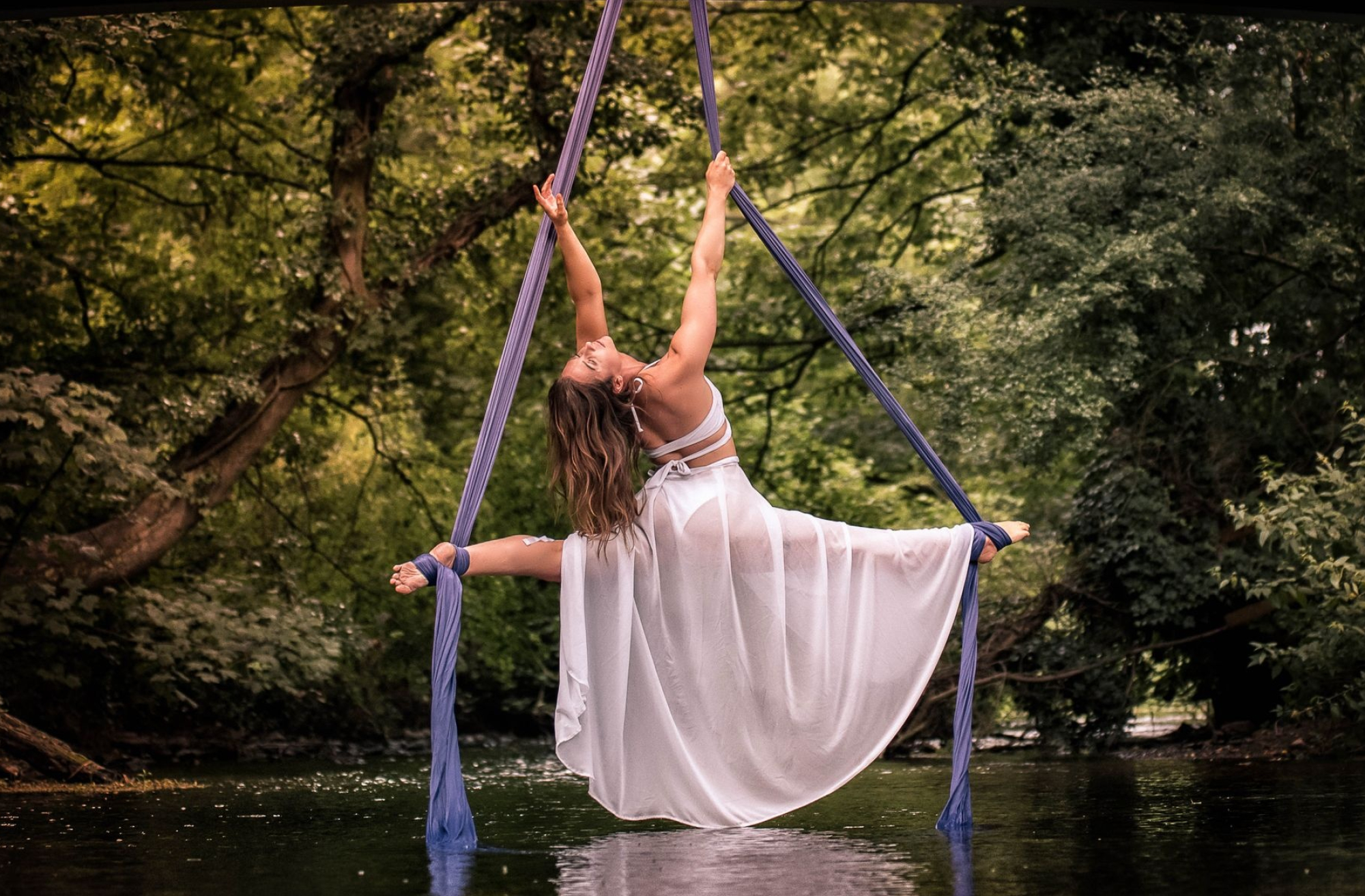 Aerial Silks: Artistic choreography in the air performed by a gymnast flying above the river. 2000x1320 HD Background.