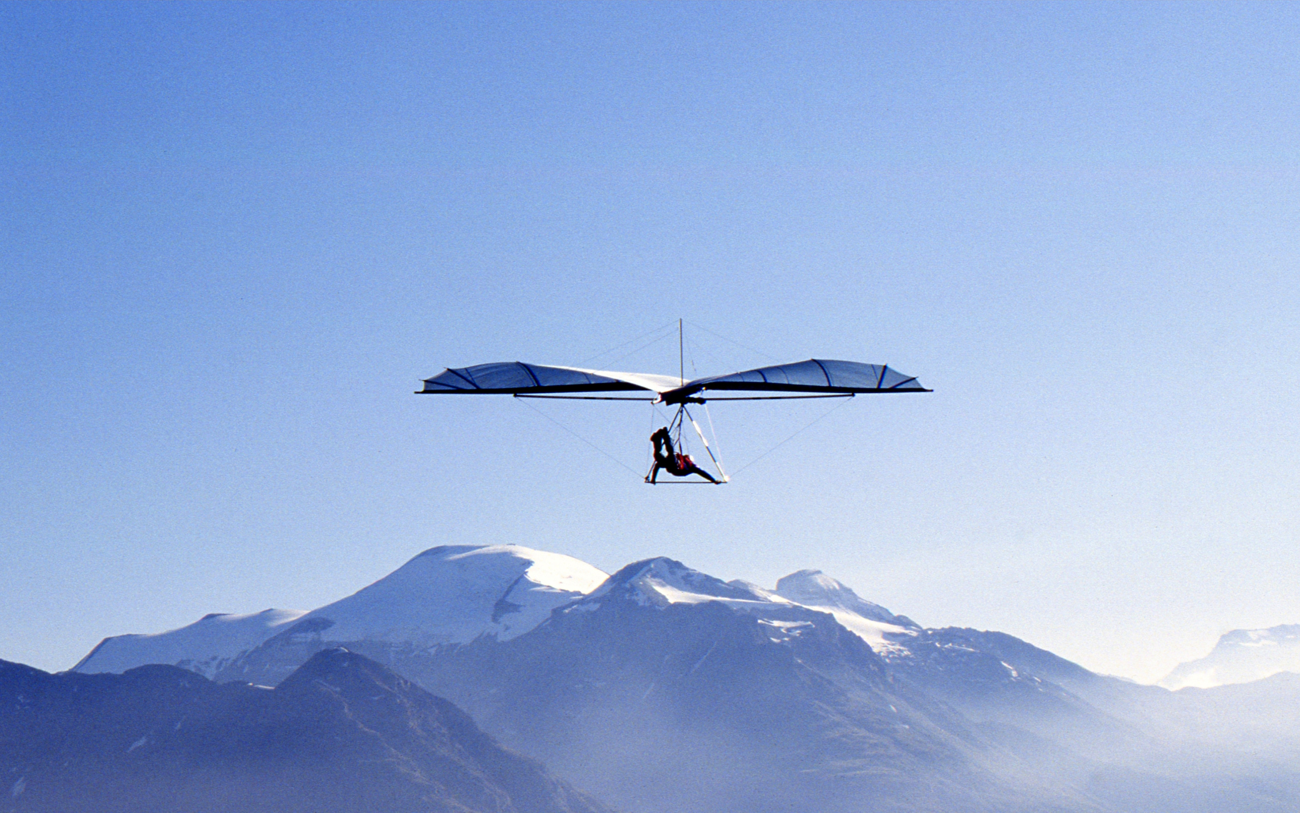 Gliding: Operated foot-launched hang glider near the mountains, Extreme sport. 2560x1600 HD Wallpaper.