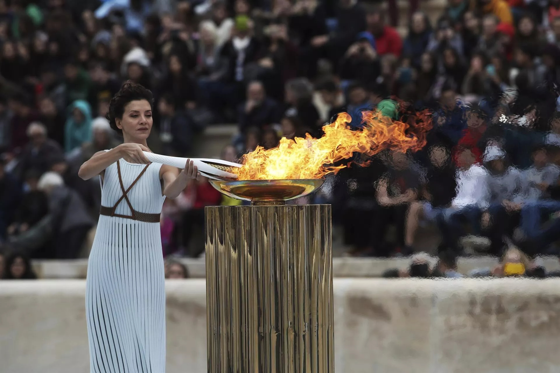 Olympic Flame: Katerina Lehou, A Greek actress, Lighting an Olympic torch during a handover ceremony, Athens, Greece, 2018 Winter Games. 1920x1280 HD Wallpaper.