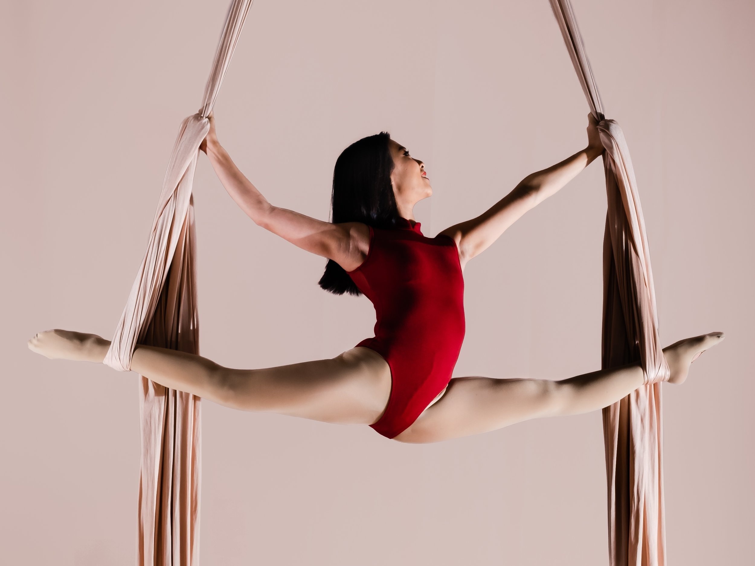 Aerial Silks: A stretch in the air performed by a gymnast with tissues. 2500x1880 HD Background.