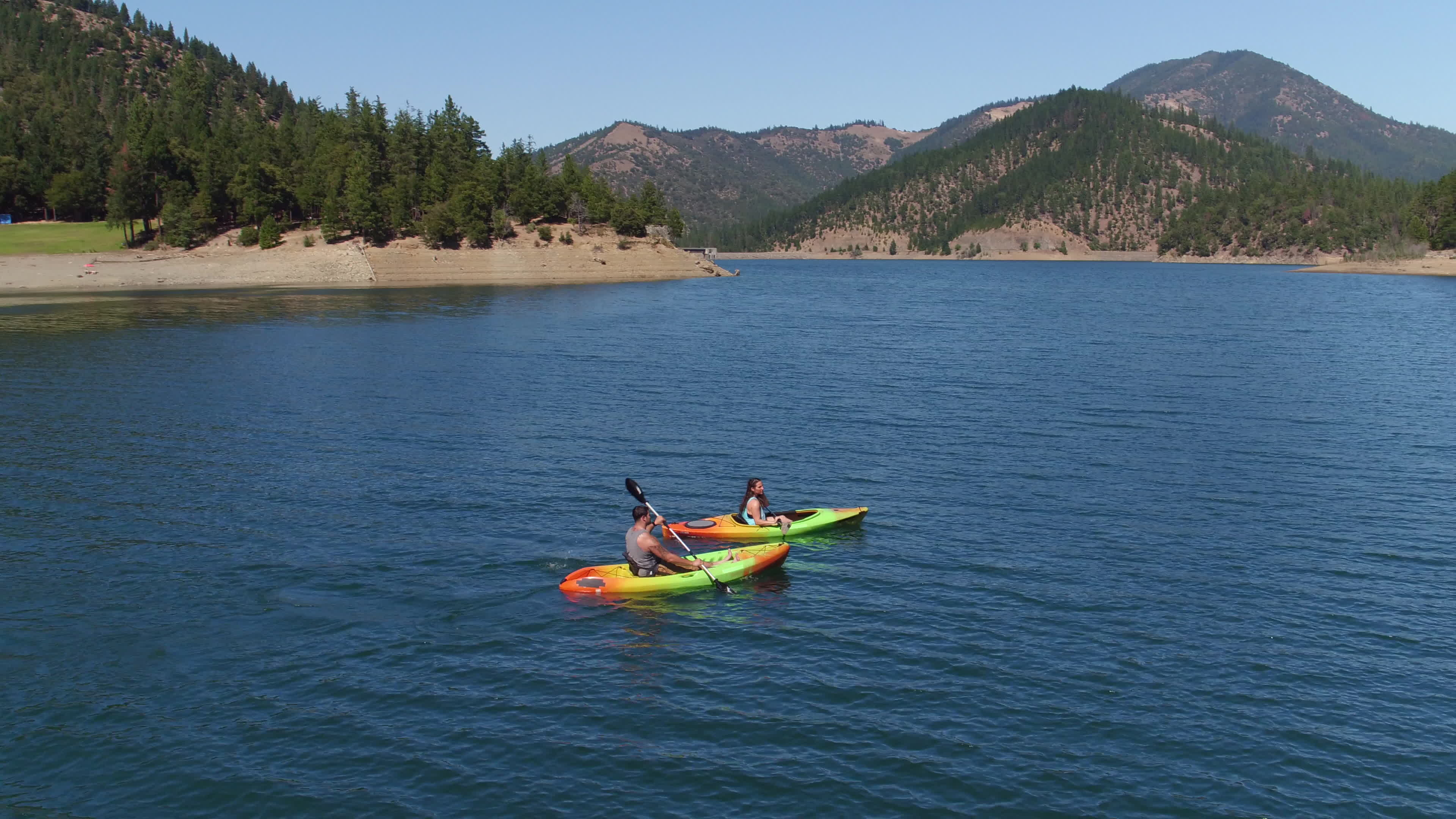 Kayaking: A couple travels across the lakes in two single-seat kayaks. 3840x2160 4K Wallpaper.