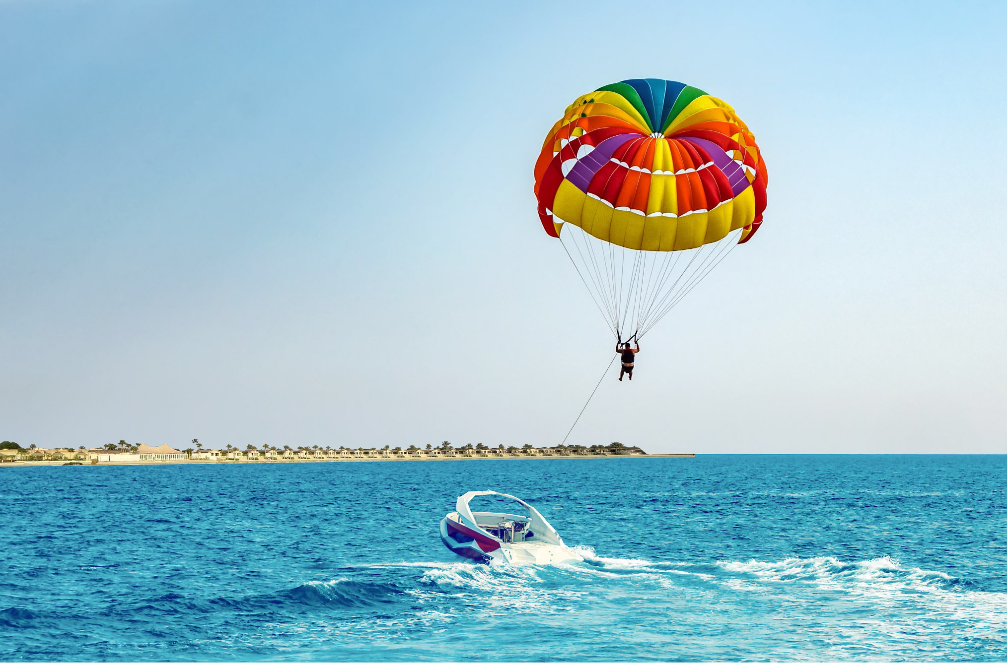 Parasailing: A man sailing in the air, A beautifully colored parachute, A recreational kiting activity, Saudi Arabia, Aqua sports. 2030x1340 HD Wallpaper.