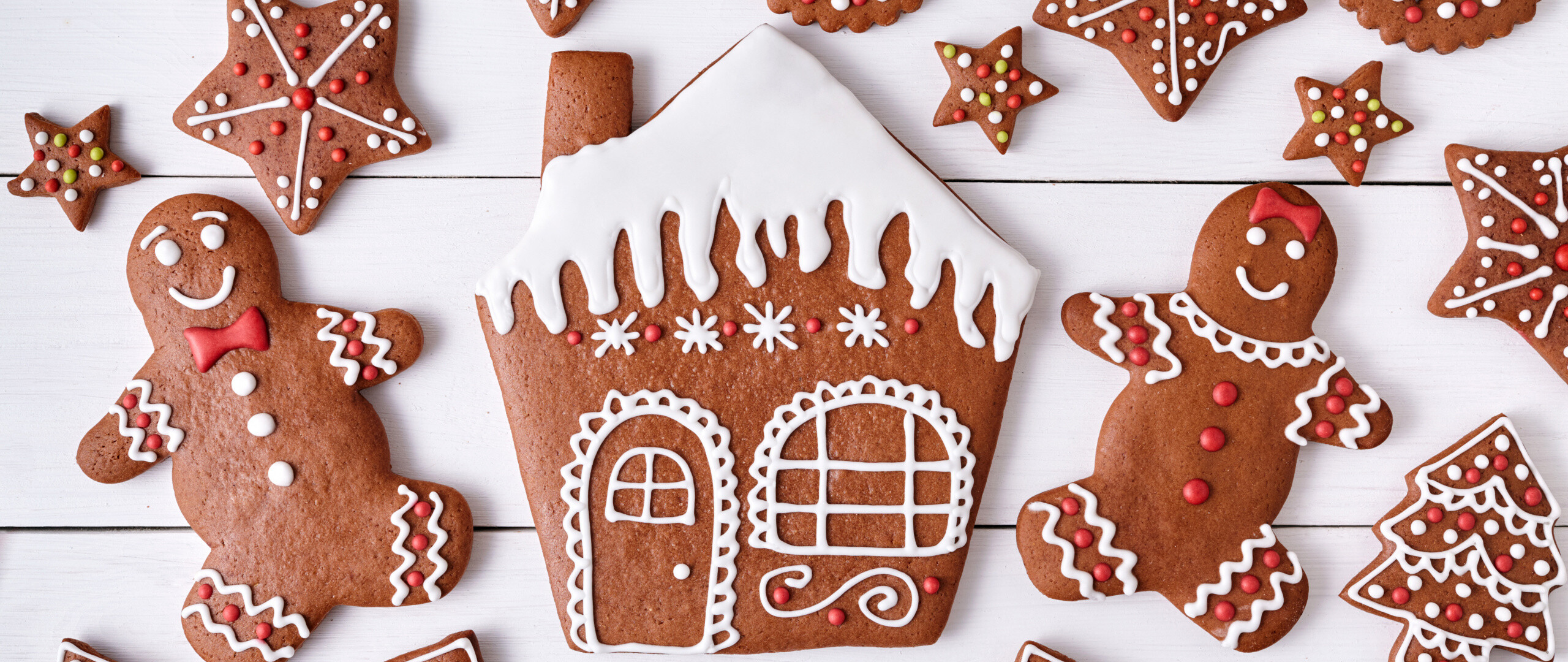 Gingerbread House: Fresh-baked hand-decorated ginger cookies, Elaborate ornaments, Christmas bakery. 2560x1080 Dual Screen Background.