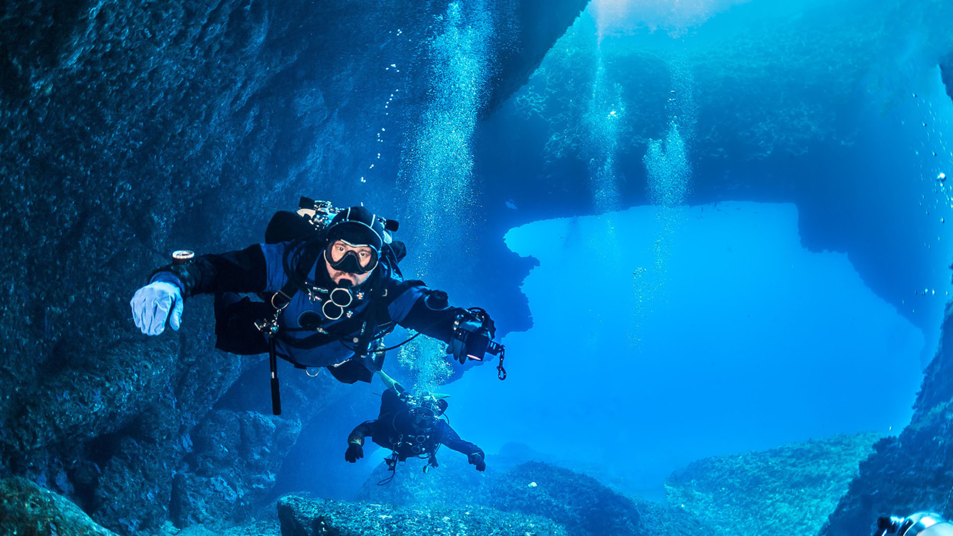 Diving: Divers explore a flooded cave system in Greece, Extreme underwater activity. 1920x1080 Full HD Background.