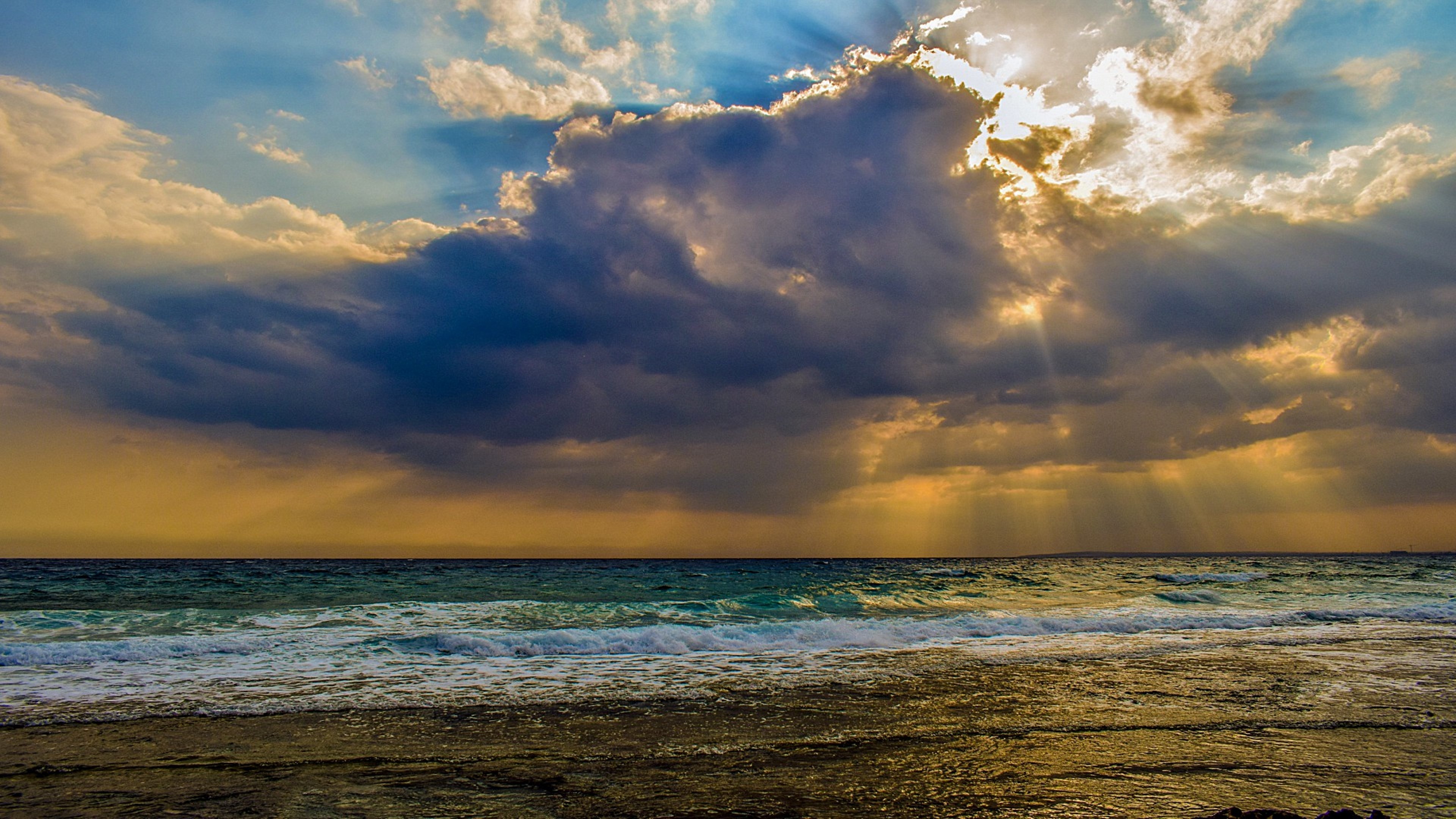 Seascape: The sun breaks through the clouds, Foamy coastal waves, Sea surface. 3840x2160 4K Background.