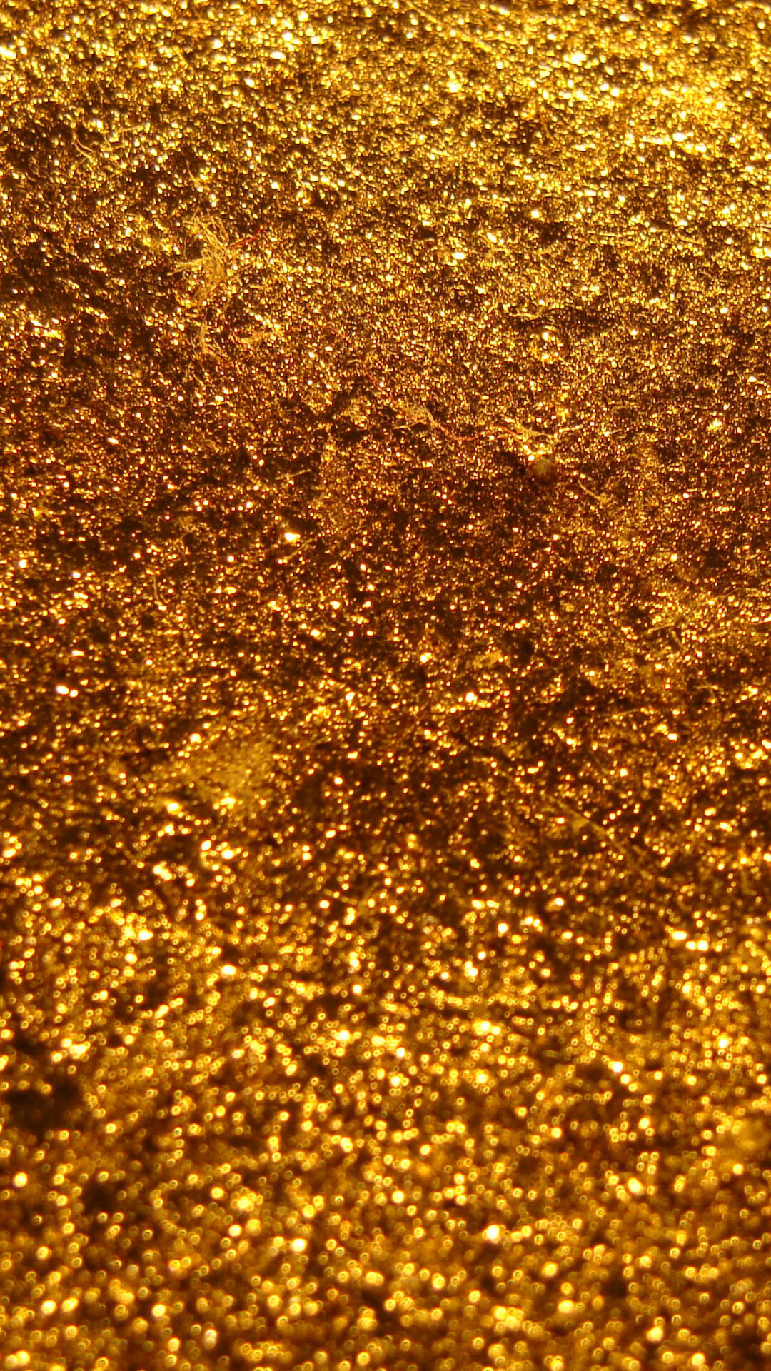 Gold Glitter: Slightly reddish yellow particles - the powder made of the pure 24 karat metal. 1080x1920 Full HD Background.