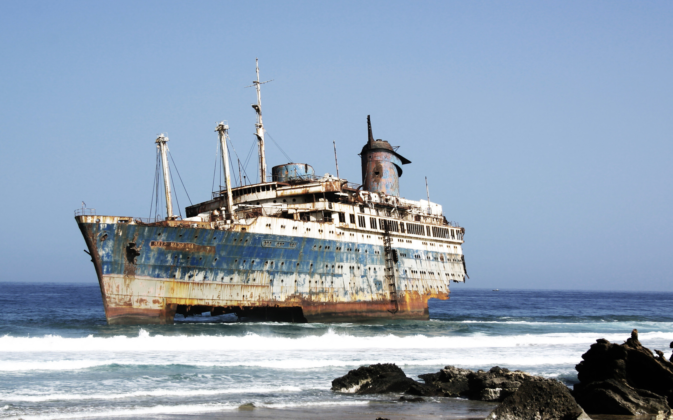 Ghost Ship: A shipwreck at the coast of the ocean, The front part of a commercial vessel. 2560x1600 HD Background.