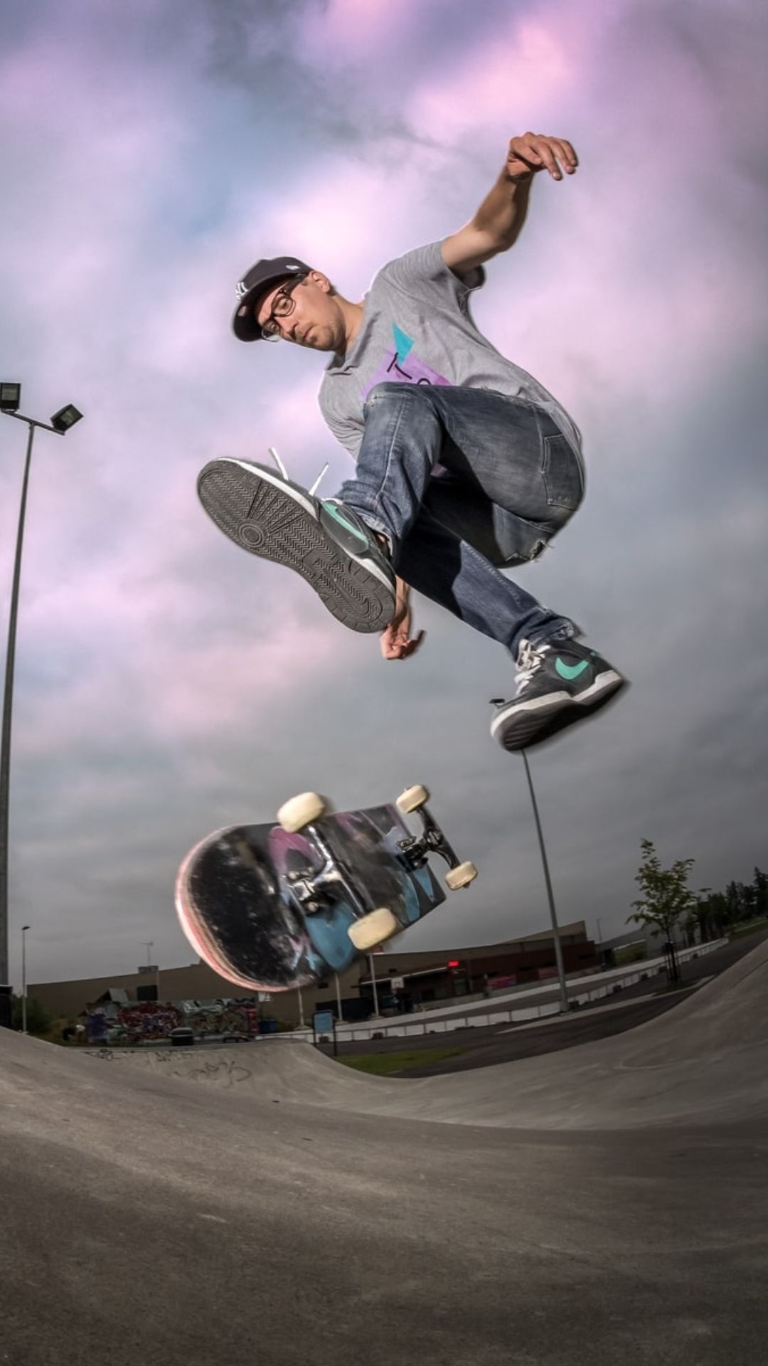 Skateboarding: Professional skater performs a trick using a modern skateboard, Action sport. 1080x1920 Full HD Background.