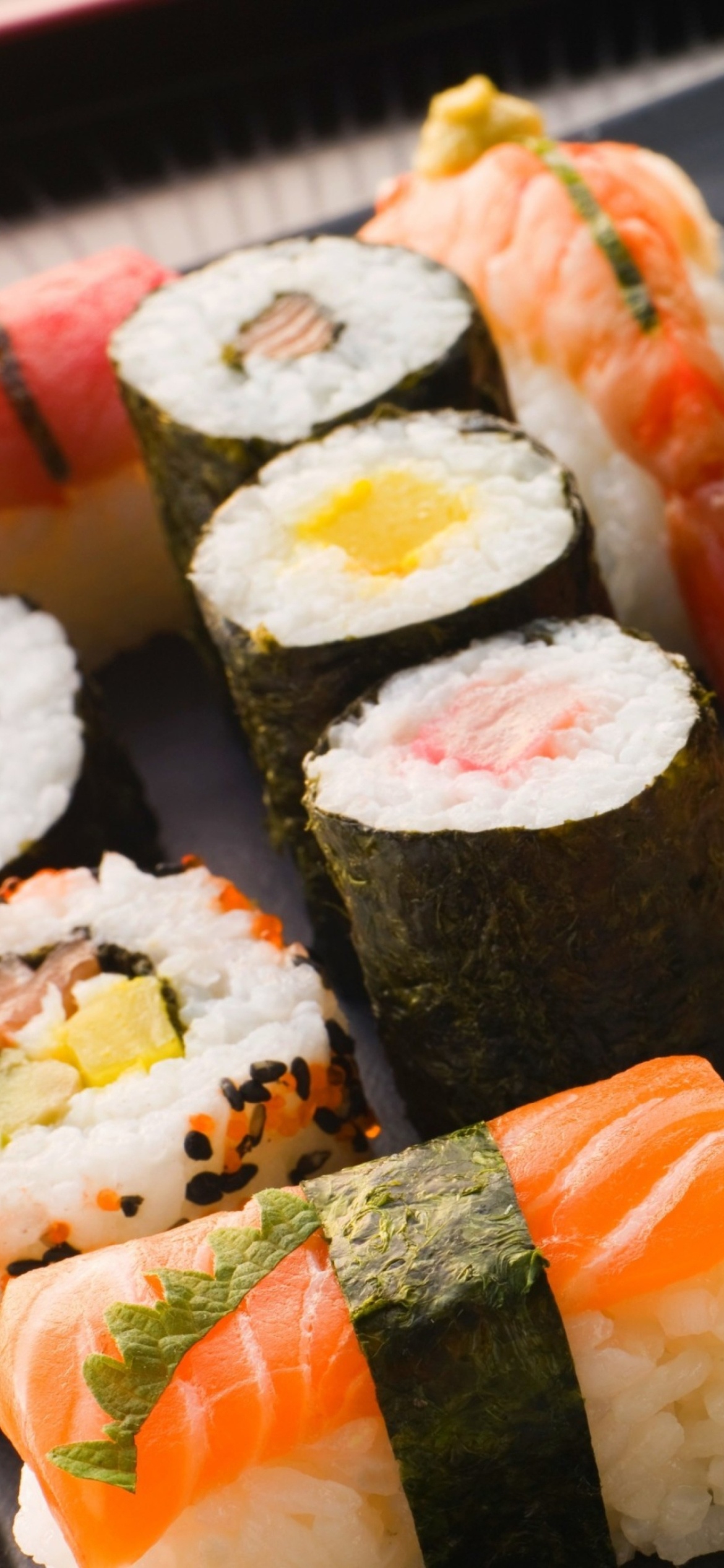 Sushi: A finger-size piece of raw fish or shellfish on a bed of rice. 1170x2540 HD Background.