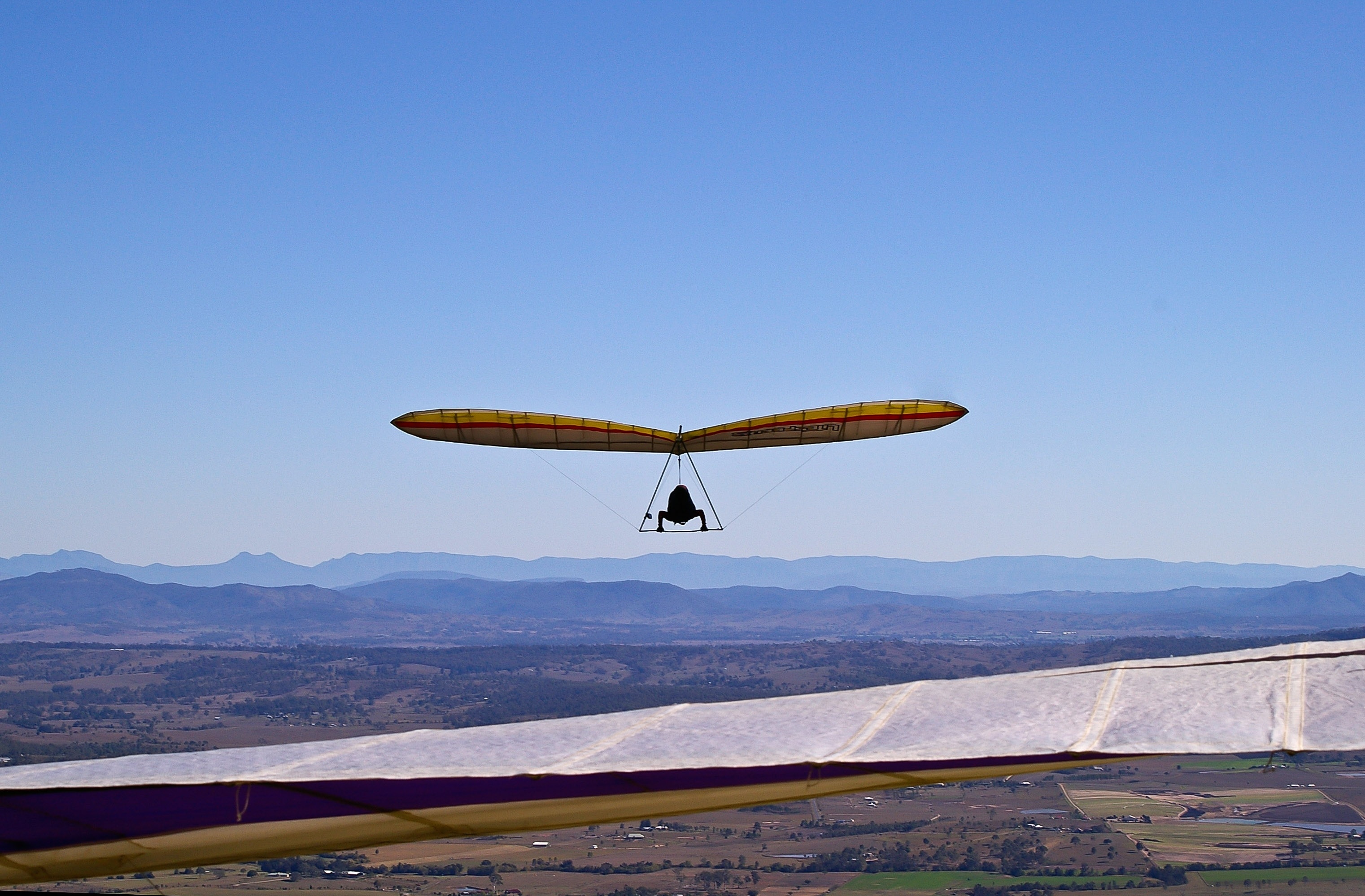 Hang Gliding: Person gliding under blue sky, Modern day gliders. 3050x2000 HD Background.