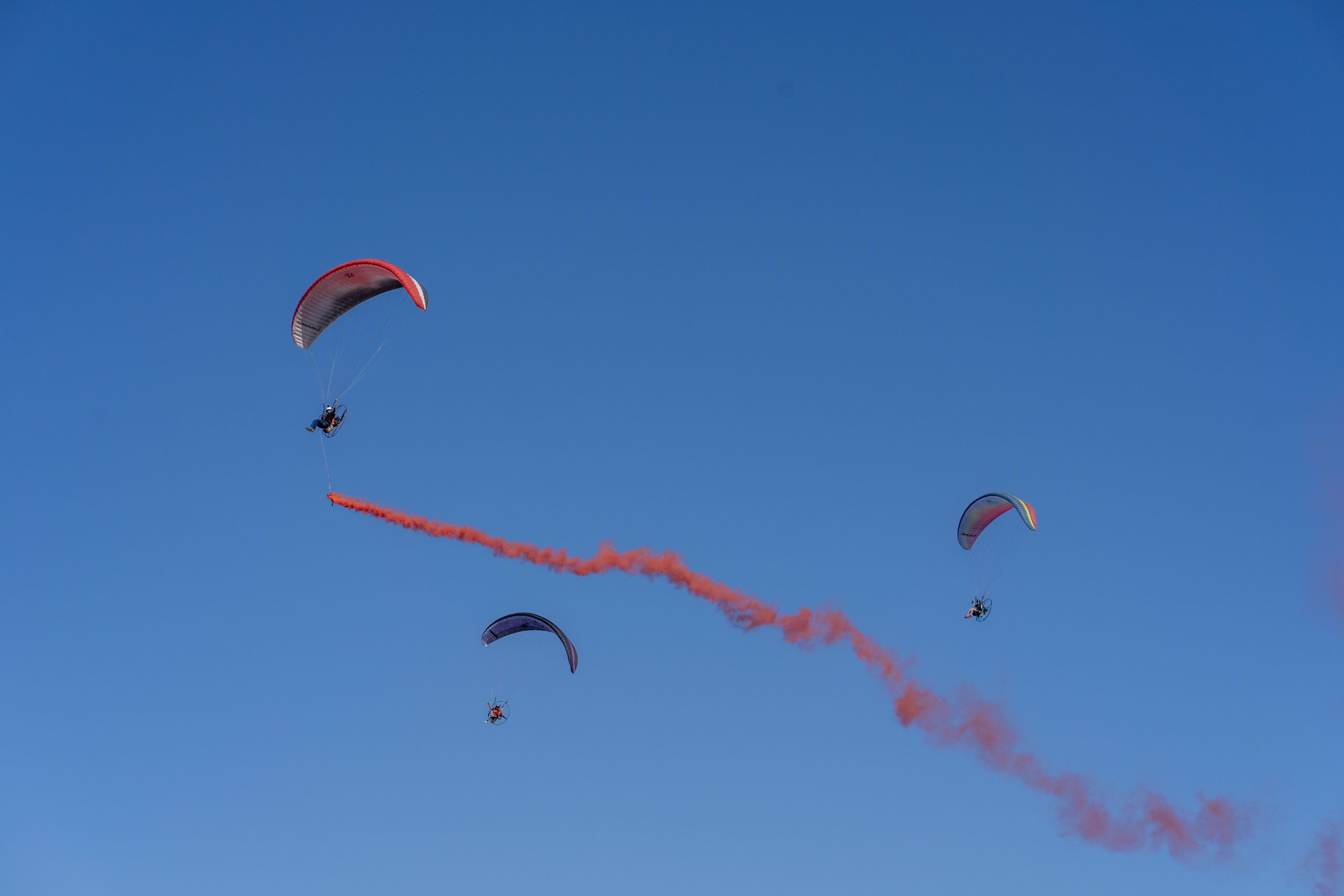 Air Sports: Sky Sports in Egypt, Three paragliders and red color vapor trail in the blue sky, Air vehicles. 2560x1710 HD Background.