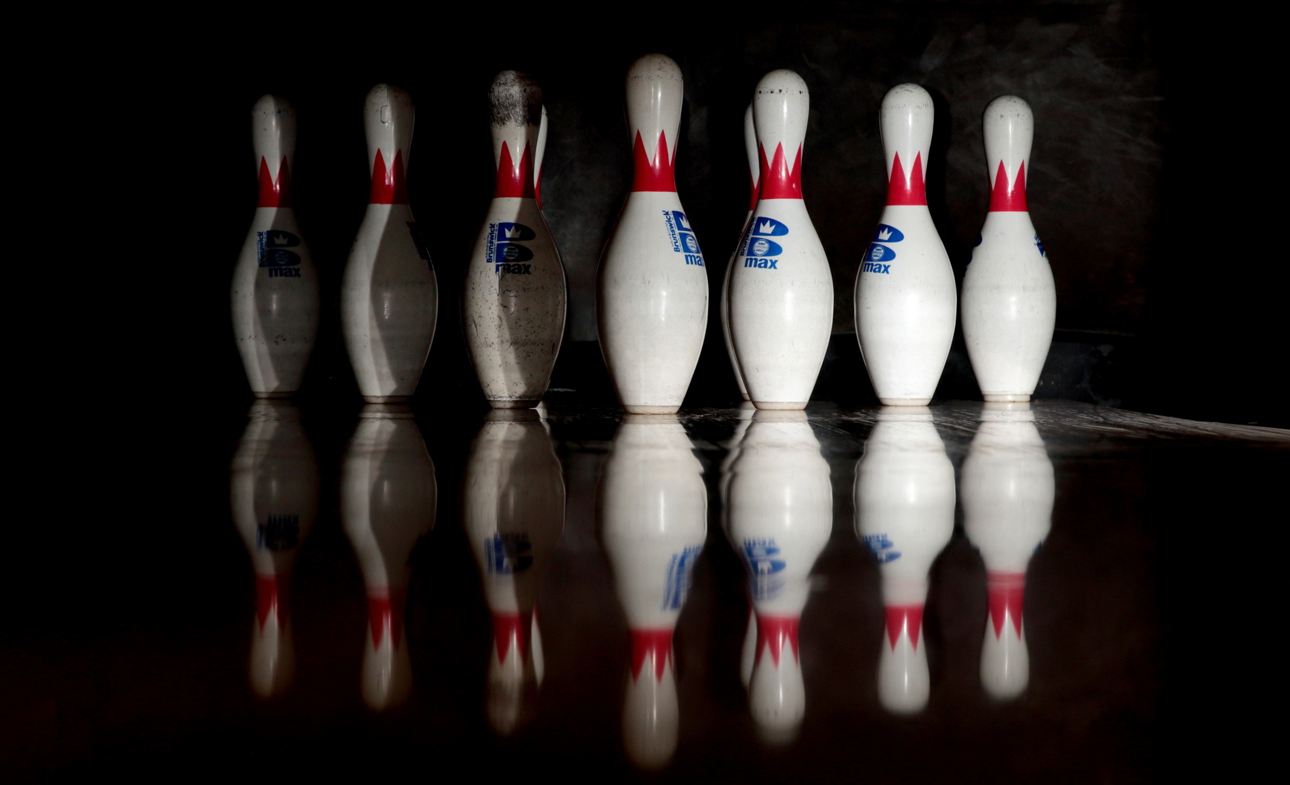 Bowling: A game played by rolling a ball down a wooden alley in order to knock down a group of ten pins. 2560x1560 HD Background.