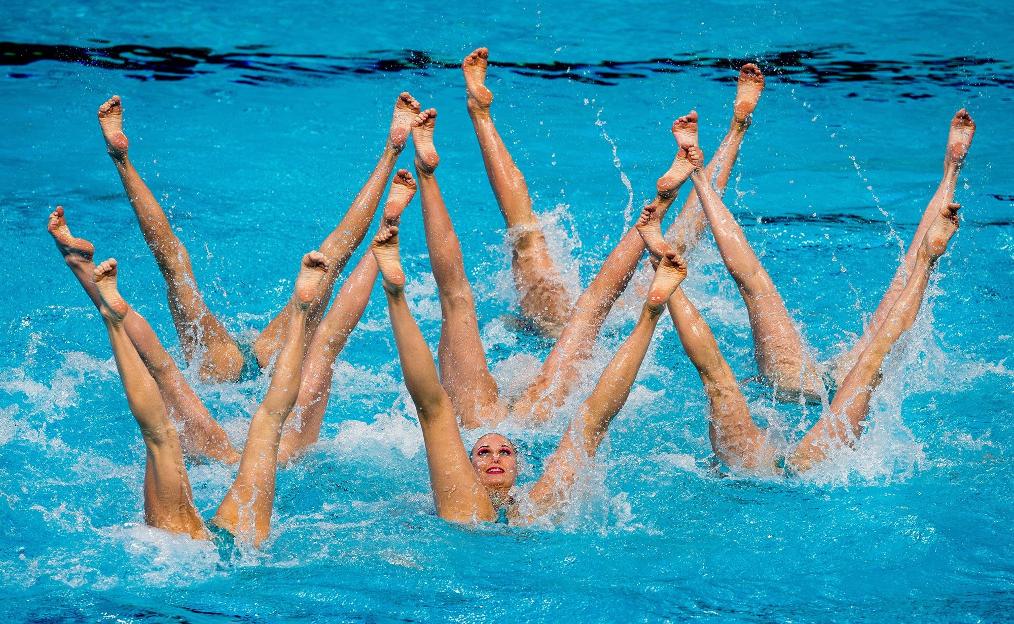 Synchronized Swimming: Girls perform basic legs techniques during the team event at the competition. 2000x1240 HD Background.