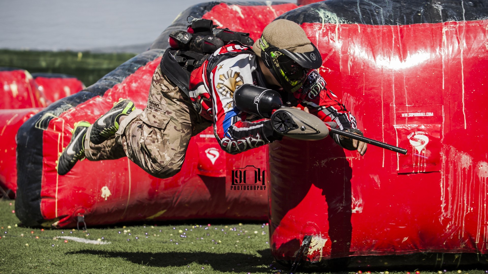 Paintball: A professional speedball player jumps out of hiding in order to quickly strike a target. 1920x1080 Full HD Background.