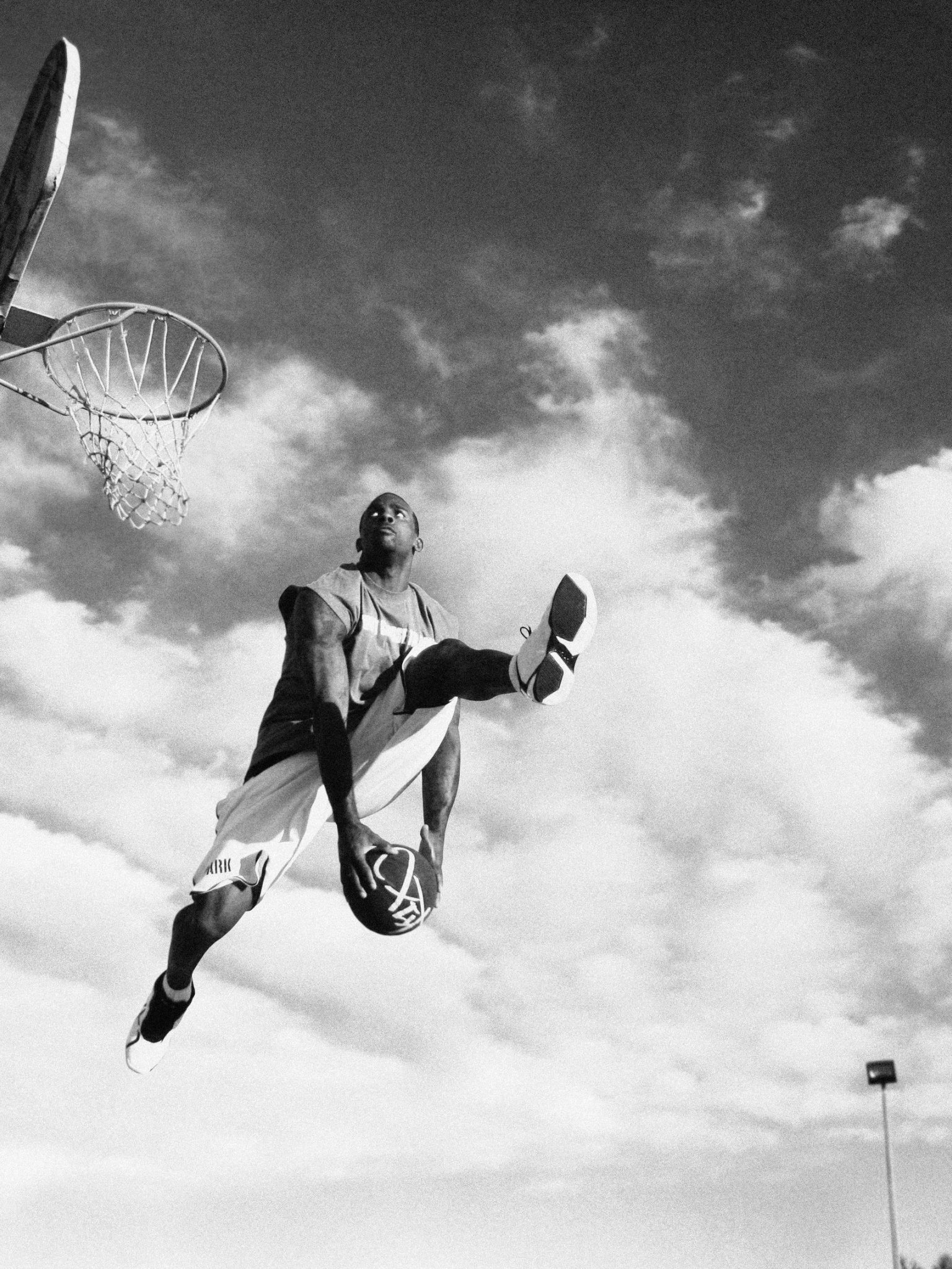 Streetball: Monochrome basketball player performs through the legs move, Competitive sport. 1540x2050 HD Background.