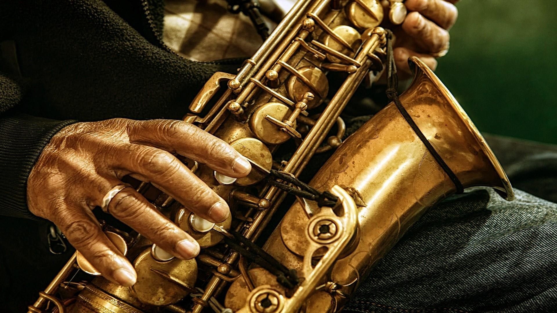 Saxophone: Jazz music, A musical wind instrument in the shape of a curved metal tube with keys. 1920x1080 Full HD Background.