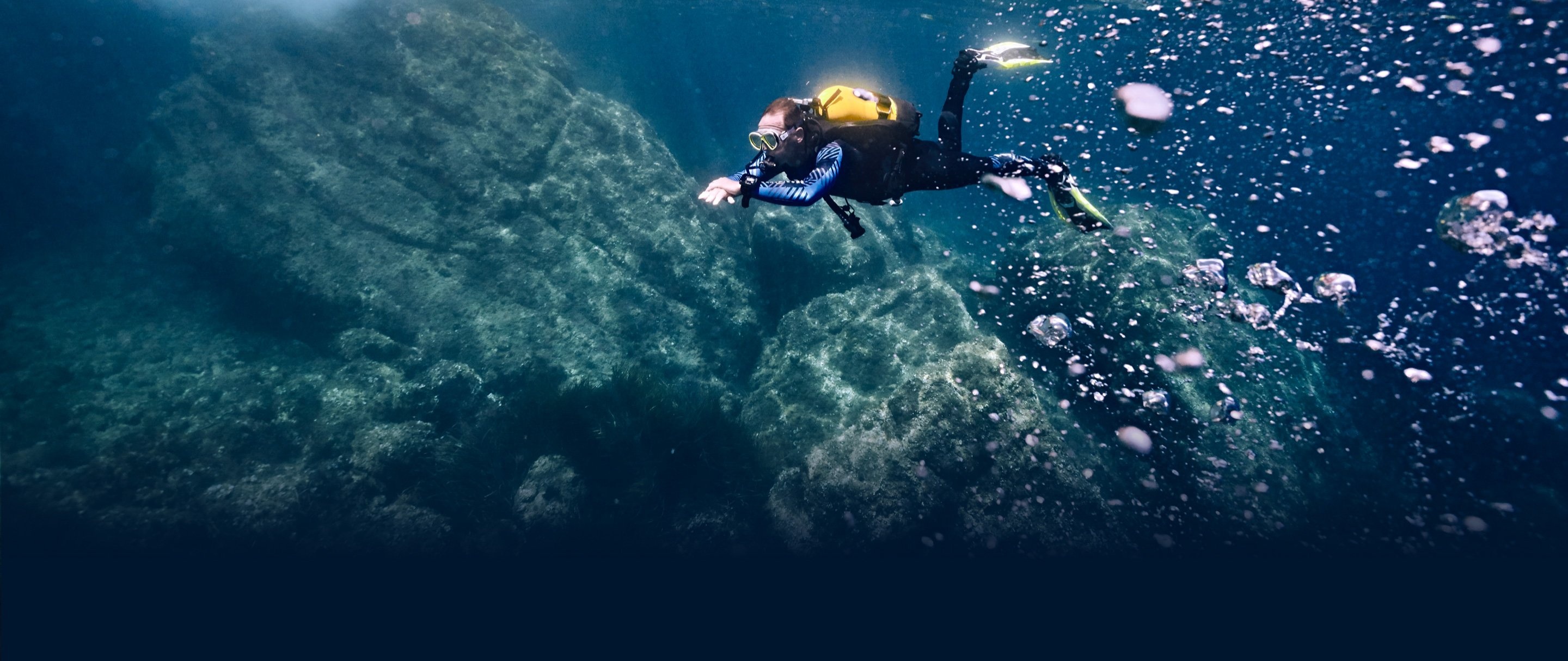 Scuba Diving: A professional diver explores the bottom of a flooded cave. 2880x1220 Dual Screen Wallpaper.