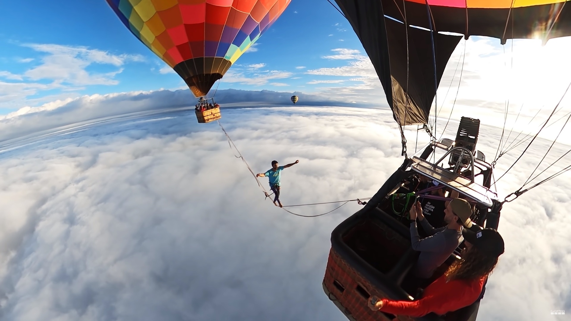 Air Sports: Extreme slacklining above the clouds between two hot-air balloons, Pro slackliner. 1920x1080 Full HD Wallpaper.