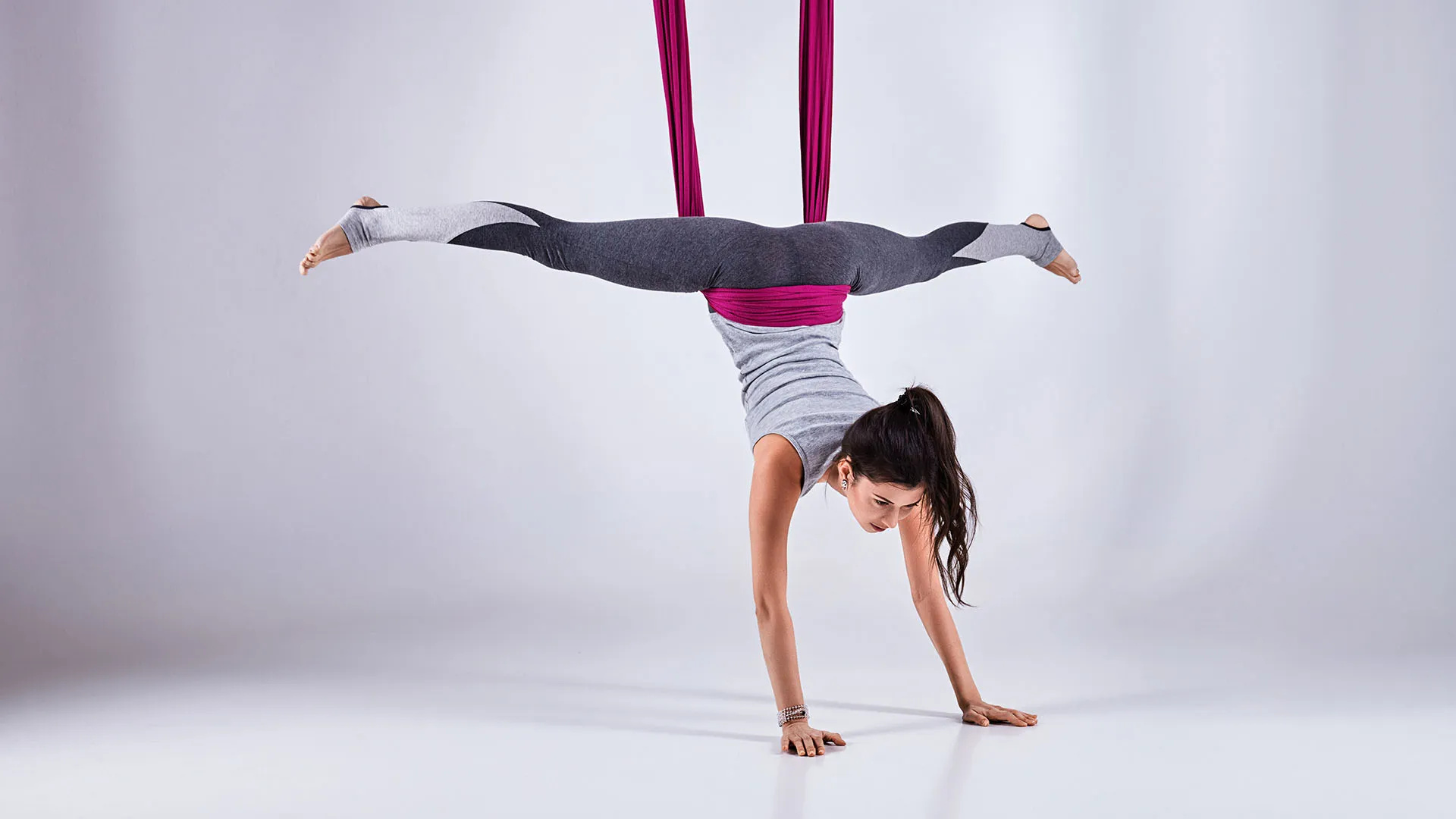 Aerial Silks: Anti-gravity yoga hand-stand exercise performed by a professional gymnast. 1920x1080 Full HD Wallpaper.